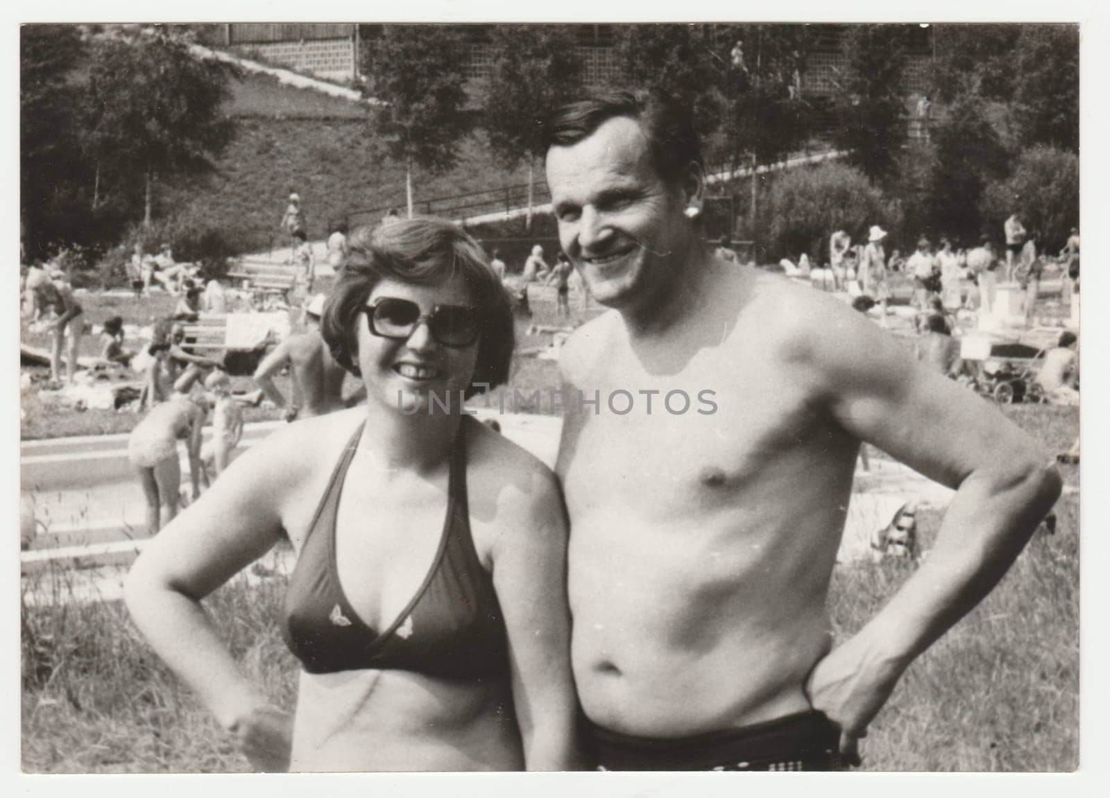 THE CZECHOSLOVAK SOCIALIST REPUBLIC - CIRCA 1980s: Vintage photo shows a mature couple next to outdoor swimming pool. Holidays - vacation theme. Retro black and white photography. Circa 1980.