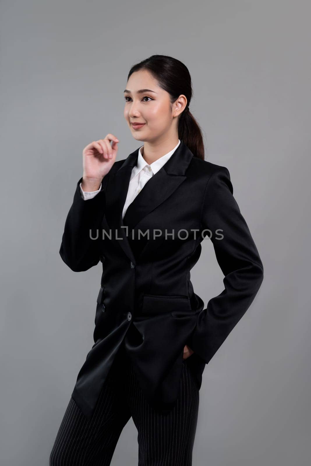 Confident young businesswoman stands on isolated background. Enthusiastic by biancoblue