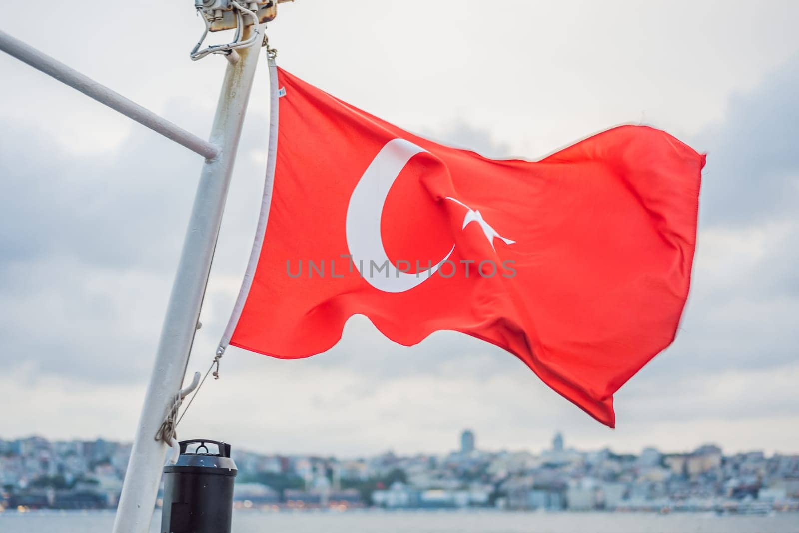 Turkish flag flying in the wind against the background of the sea and the coast.