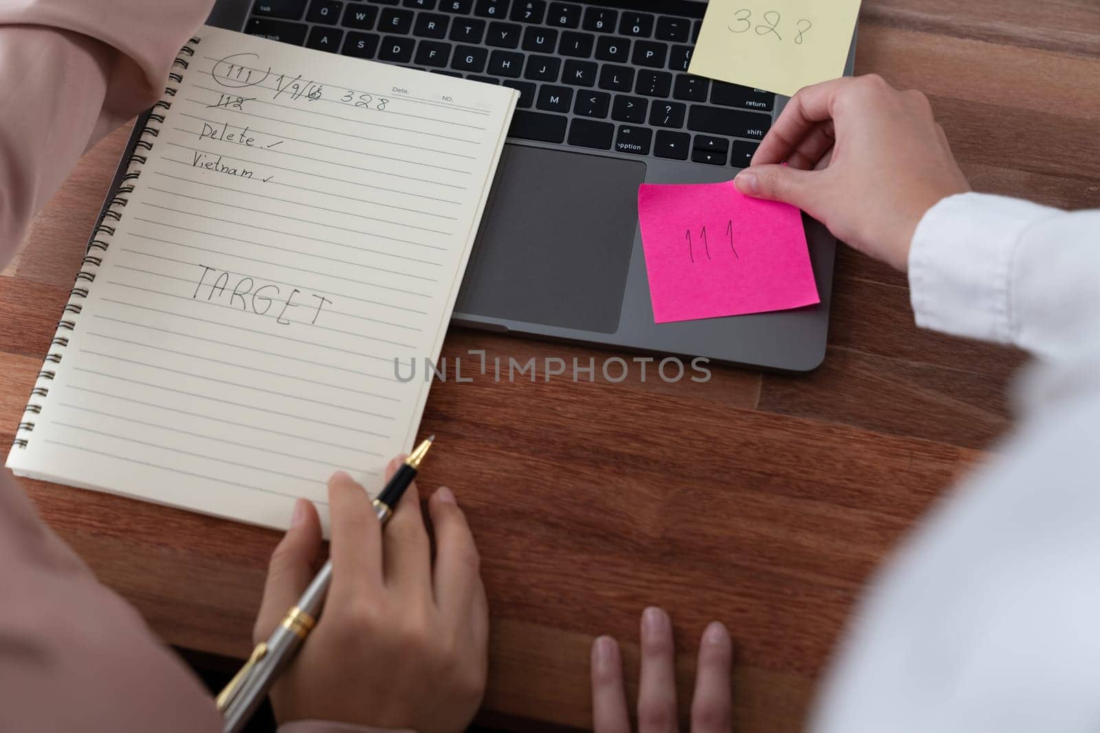 Two office lady colleague collaborating in modern office workspace, engaging in discussion and working together on laptop, writing post note as professional and modern office worker. Enthusiastic