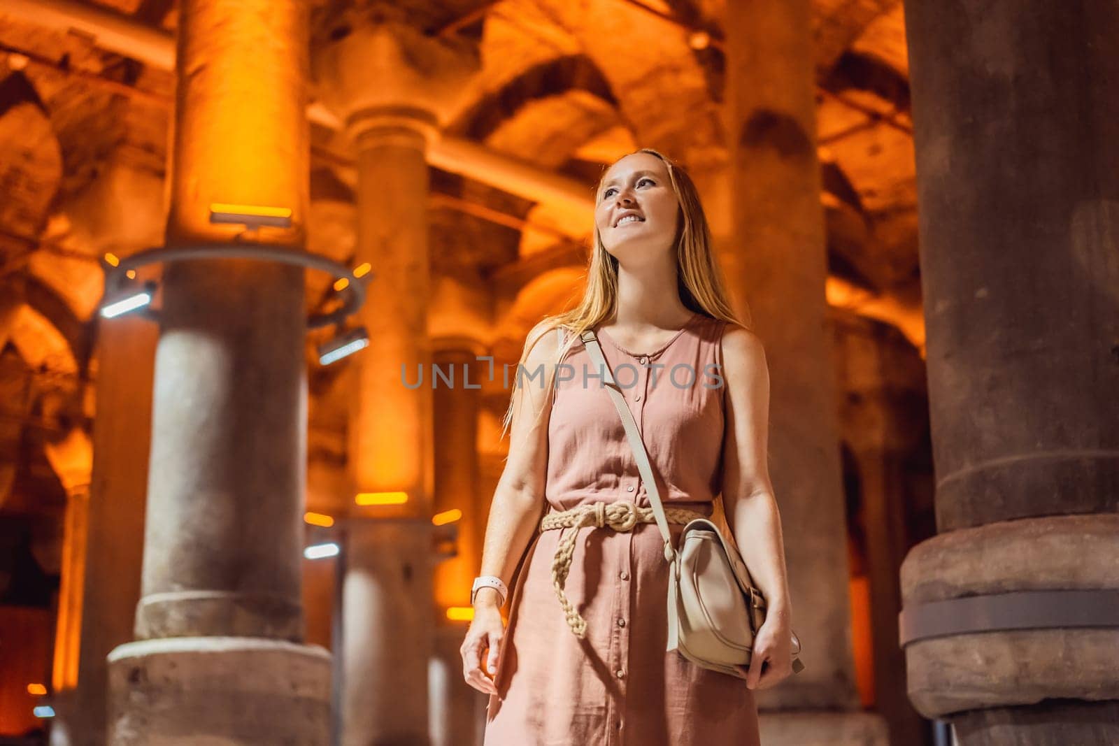 Woman tourist enjoying Beautiful cistern in Istanbul. Cistern - underground water reservoir build in 6th century, Istanbul, Turkey, Turkiye.