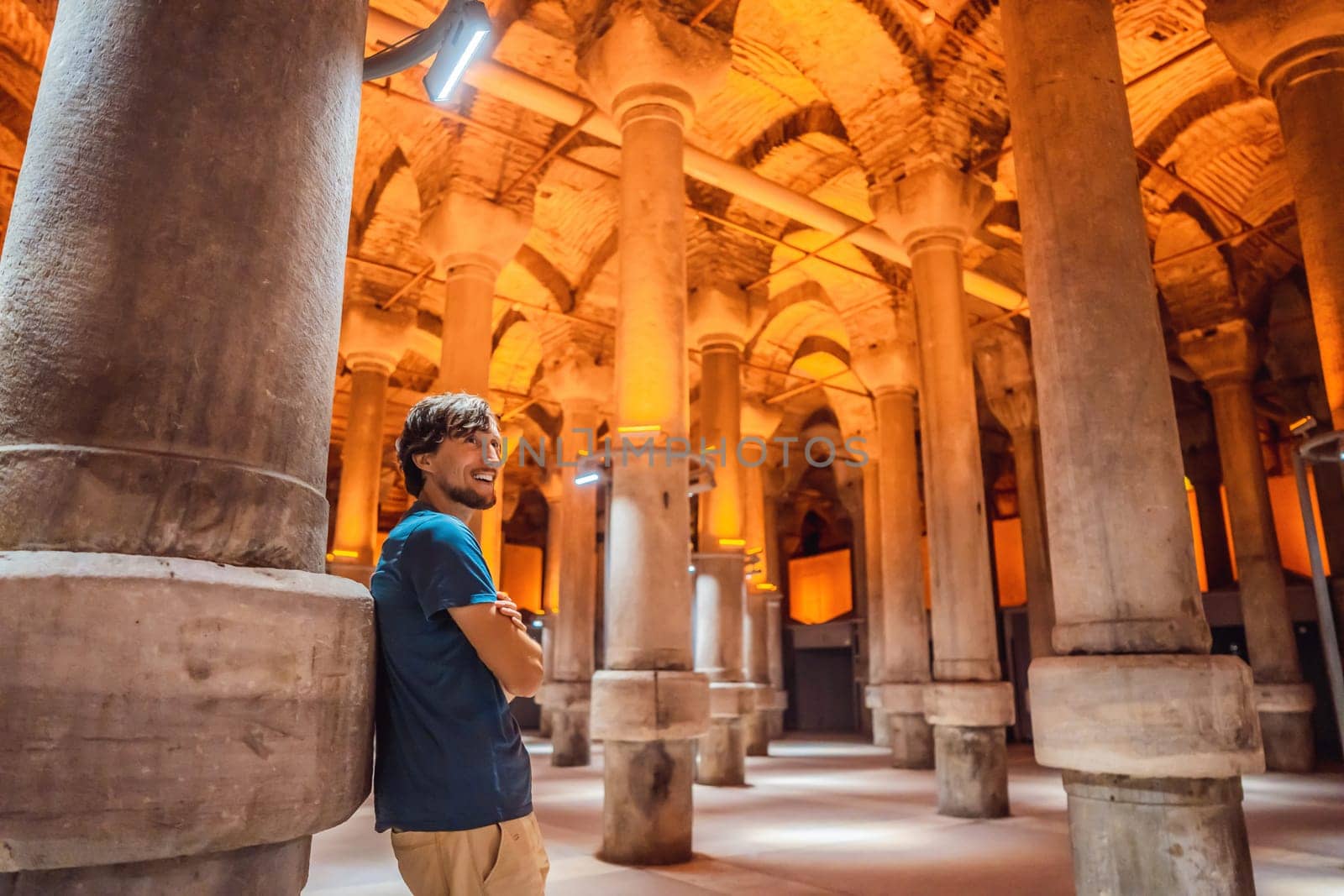 Man tourist enjoying Beautiful cistern in Istanbul. Cistern - underground water reservoir build in 6th century, Istanbul, Turkey, Turkiye.