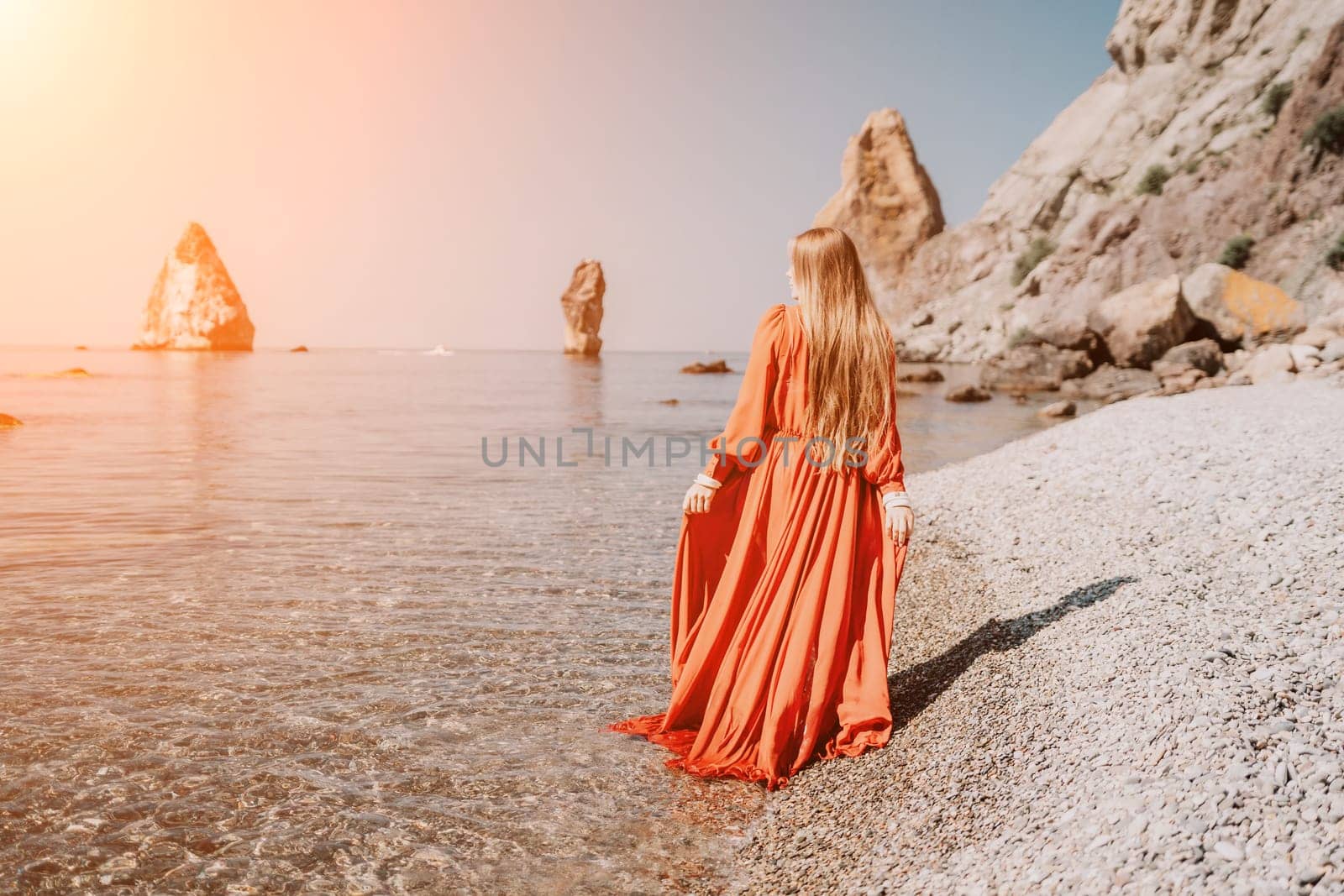 Woman travel sea. Happy tourist taking picture outdoors for memories. Woman traveler looks at the edge of the cliff on the sea bay of mountains, sharing travel adventure journey.