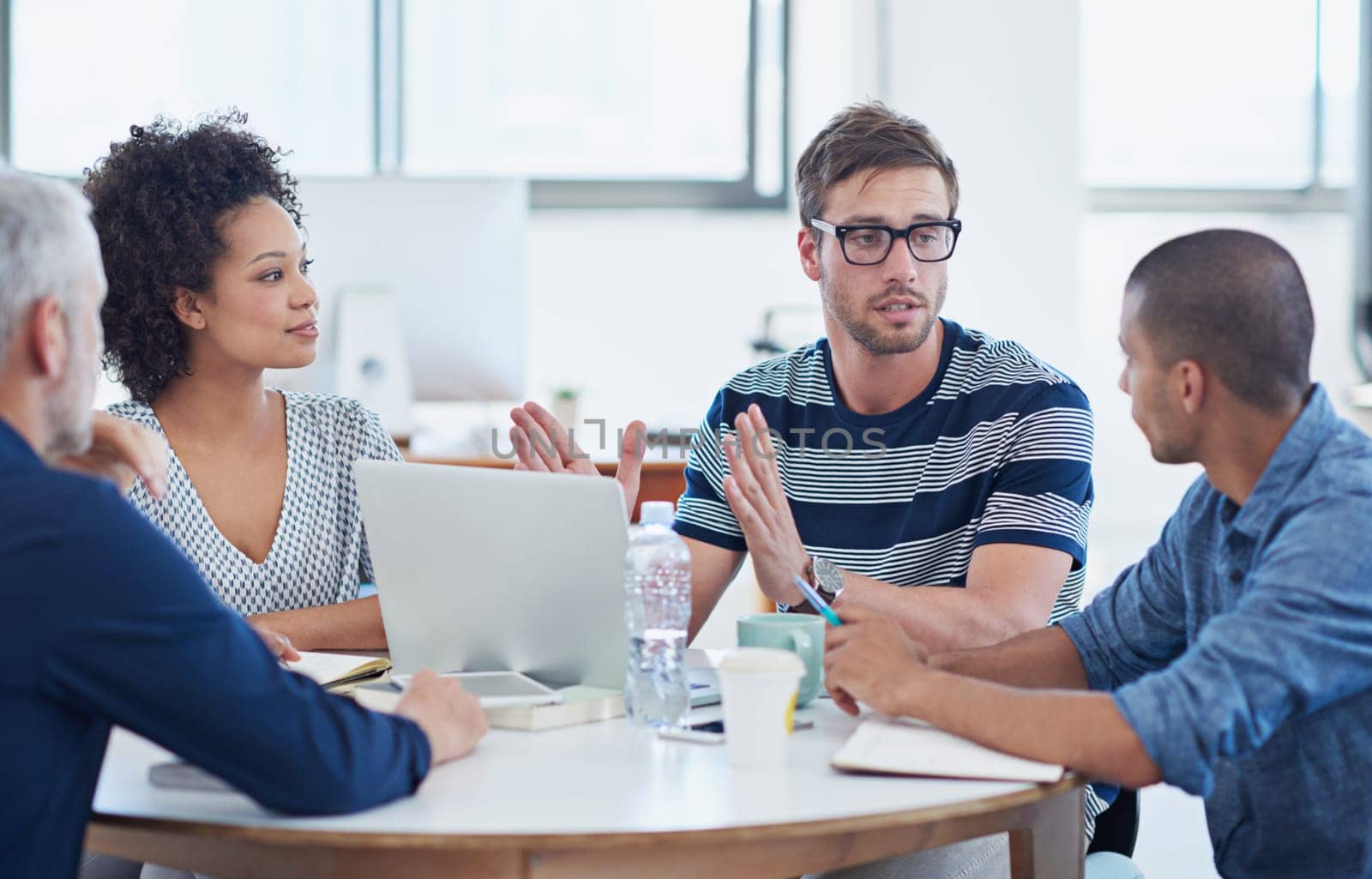 Office discussions. a group of designers at work in an office. by YuriArcurs