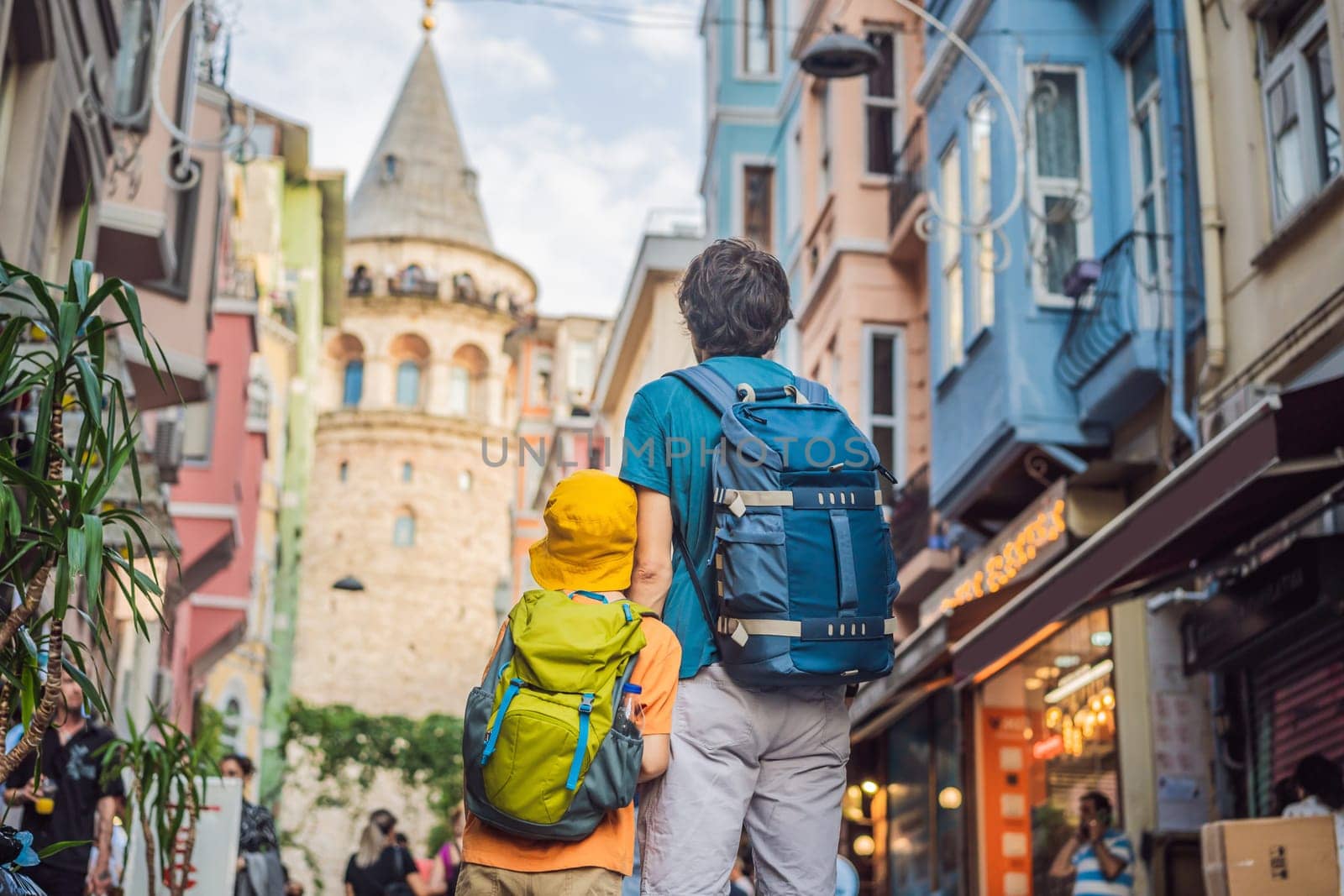 Portrait of father and son tourists with view of Galata tower in Beyoglu, Istanbul, Turkey. Turkiye. Traveling with kids concept by galitskaya