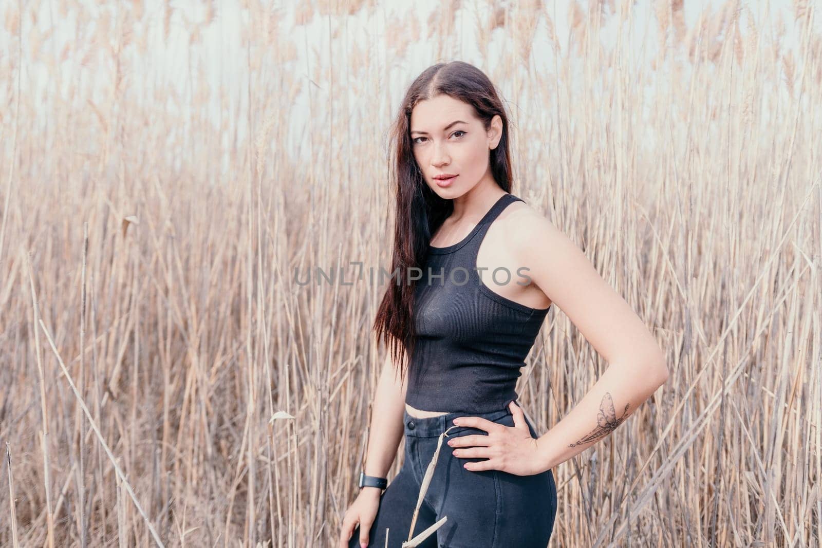 Happy young smiling woman with freckles outdoors portrait. Soft sunny colors. Outdoor close-up portrait of a young brunette woman and looking to the camera, posing against autumn nature background by panophotograph