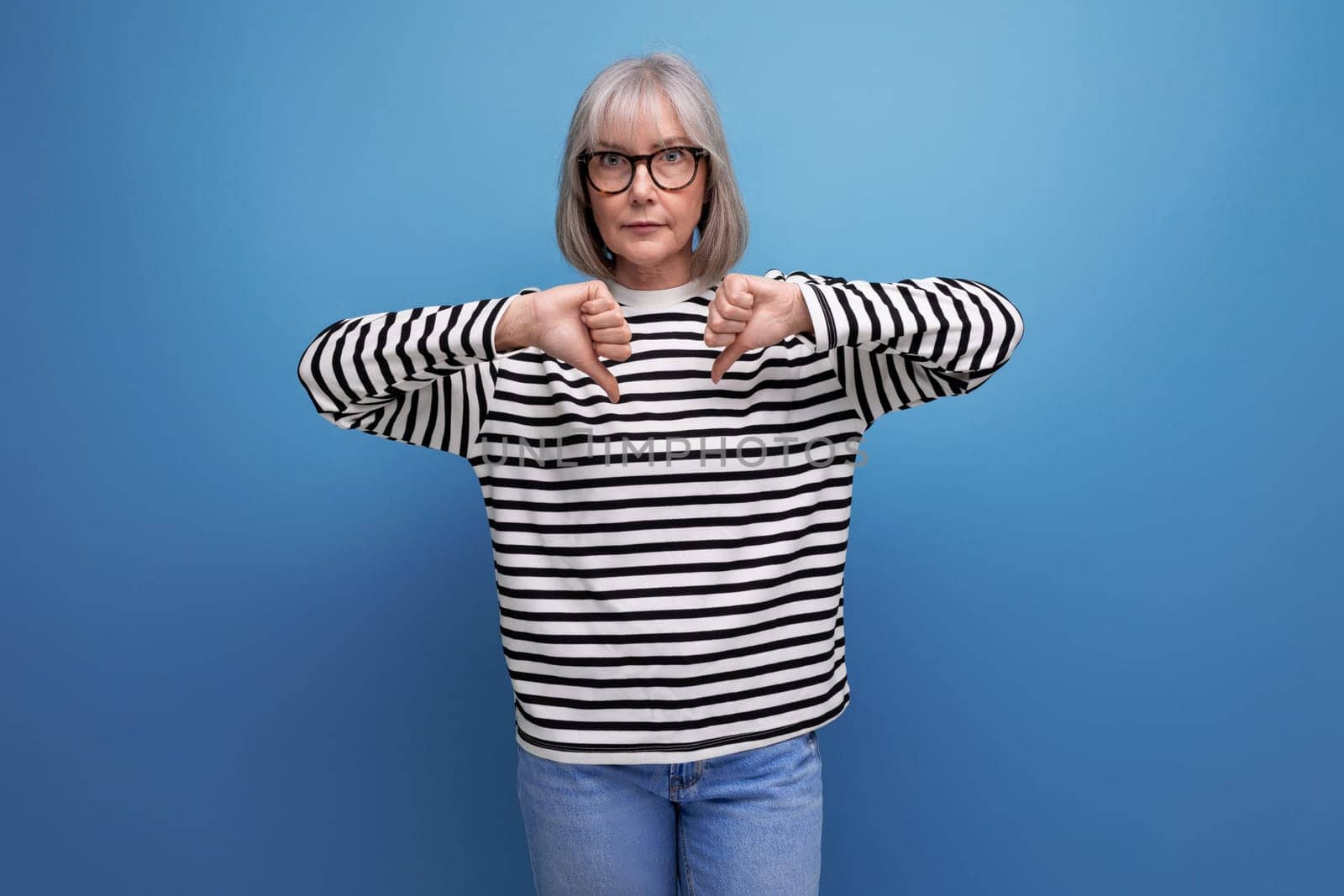 successful mature woman with gray hair on bright studio background by TRMK