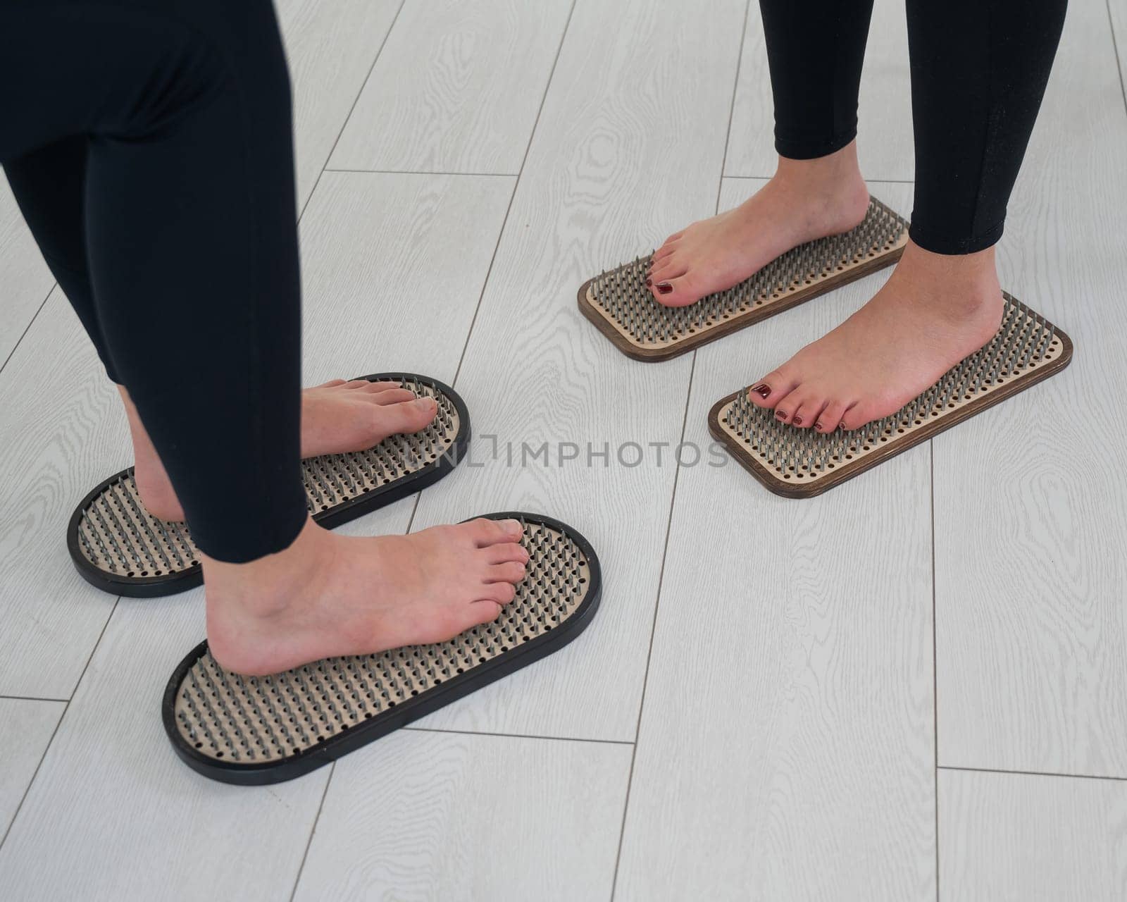 Caucasian and Asian women stand up sadhu boards together