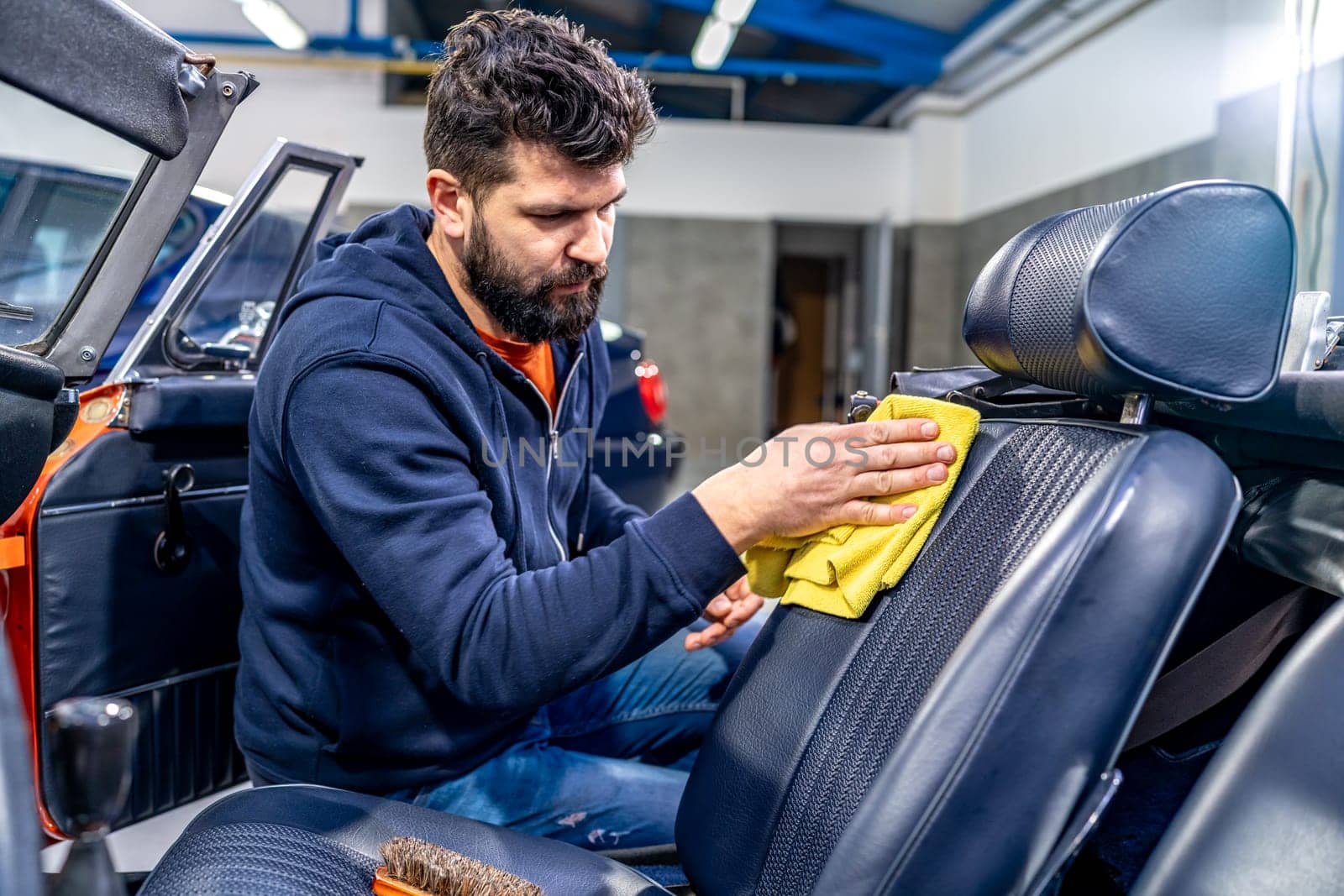 manual cleaning of the leather in the interior of the car with a micro towel by Edophoto