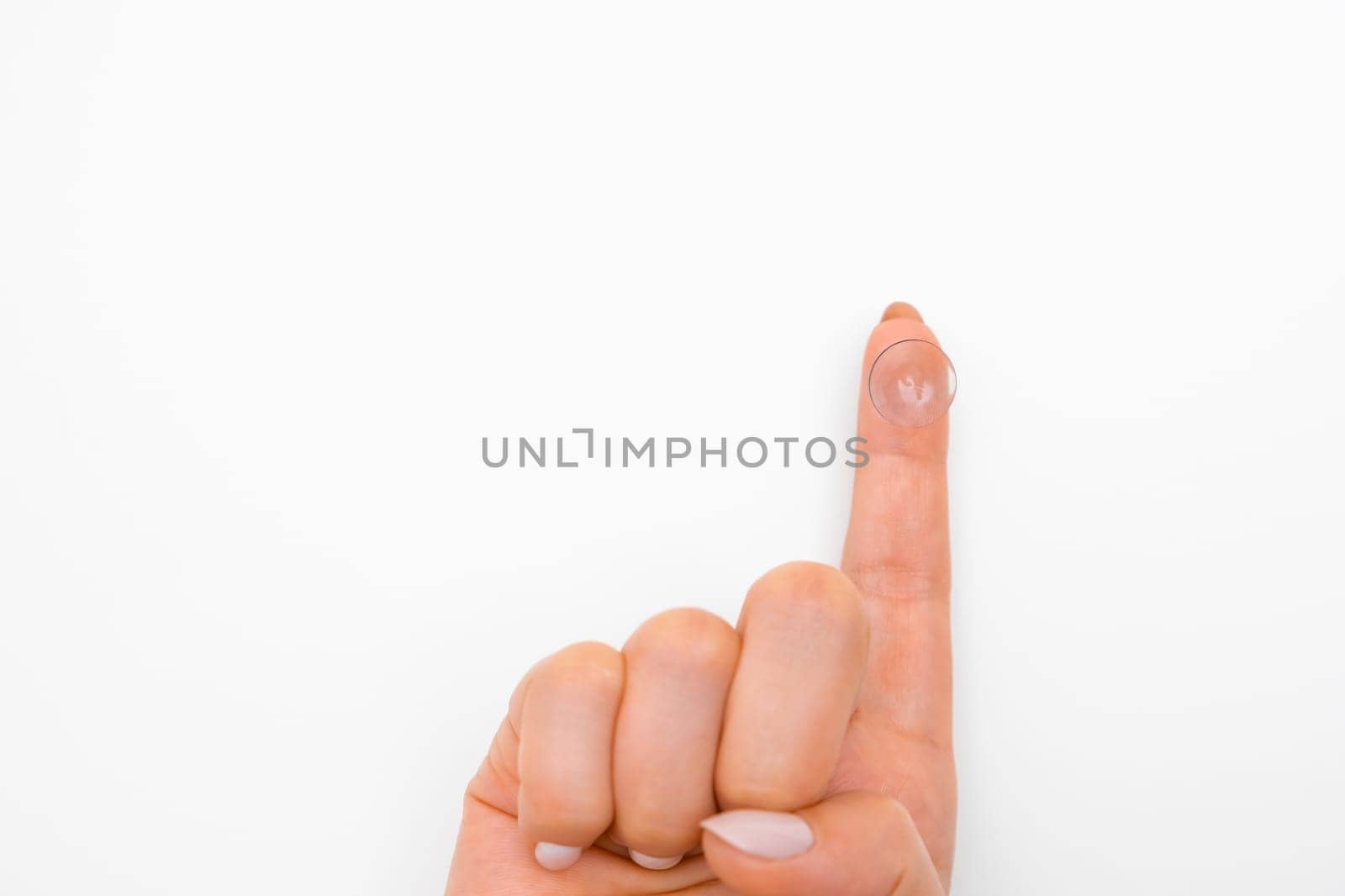 Close up finger with contact lens on the white background. Eye treatment concept