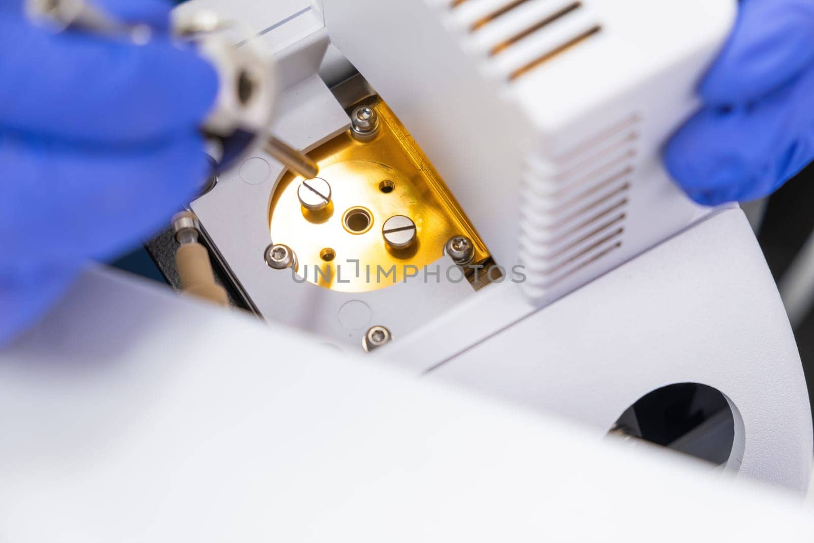 Chemist inzert a nebuliser into ion source of mass spectrometer. Liquid chromatography with mass detector. Maintenance of the instrument