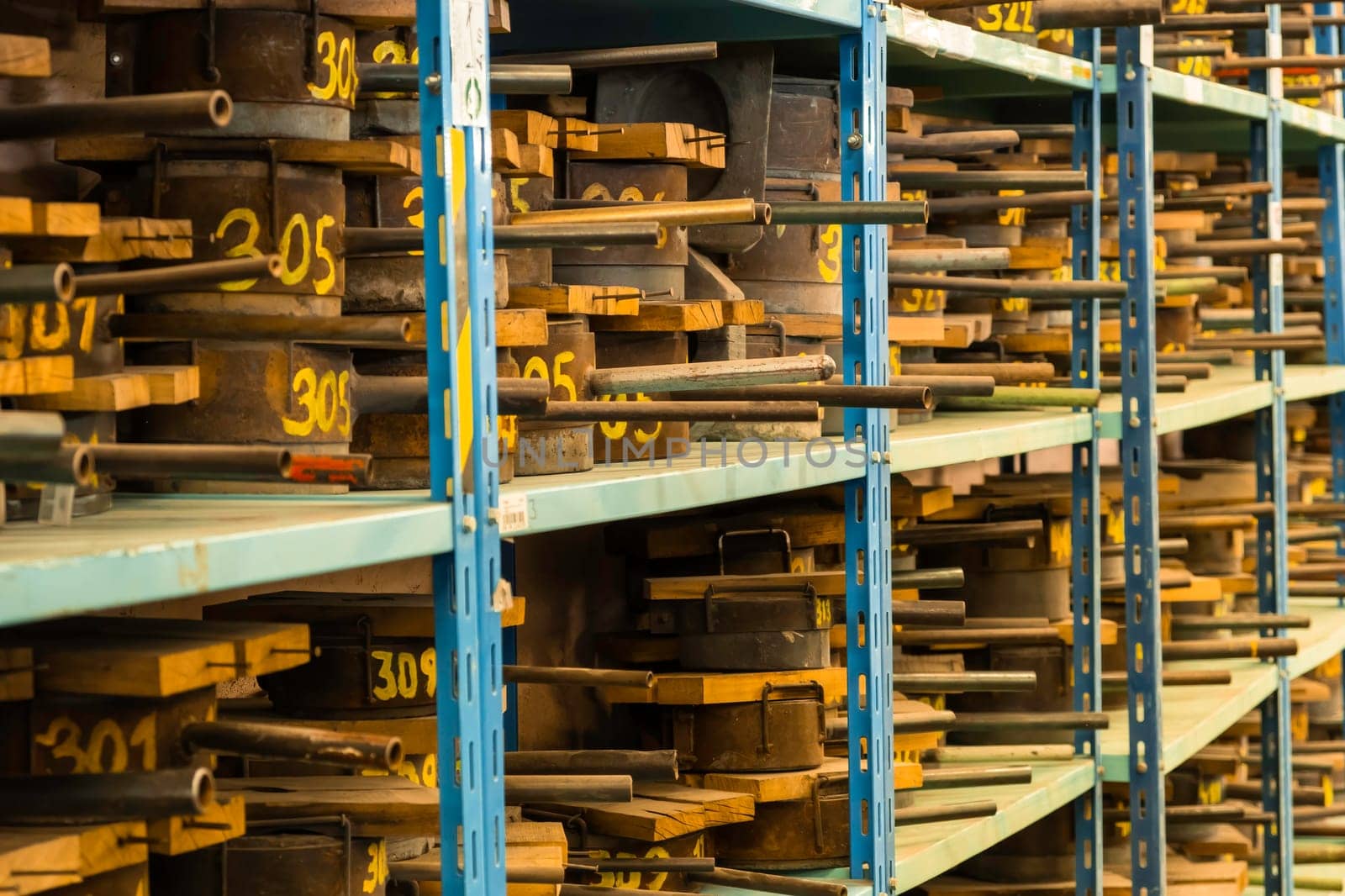 Metal molds for the production of various shapes of glass products lie on the shelves in the factory or glass manufacture.