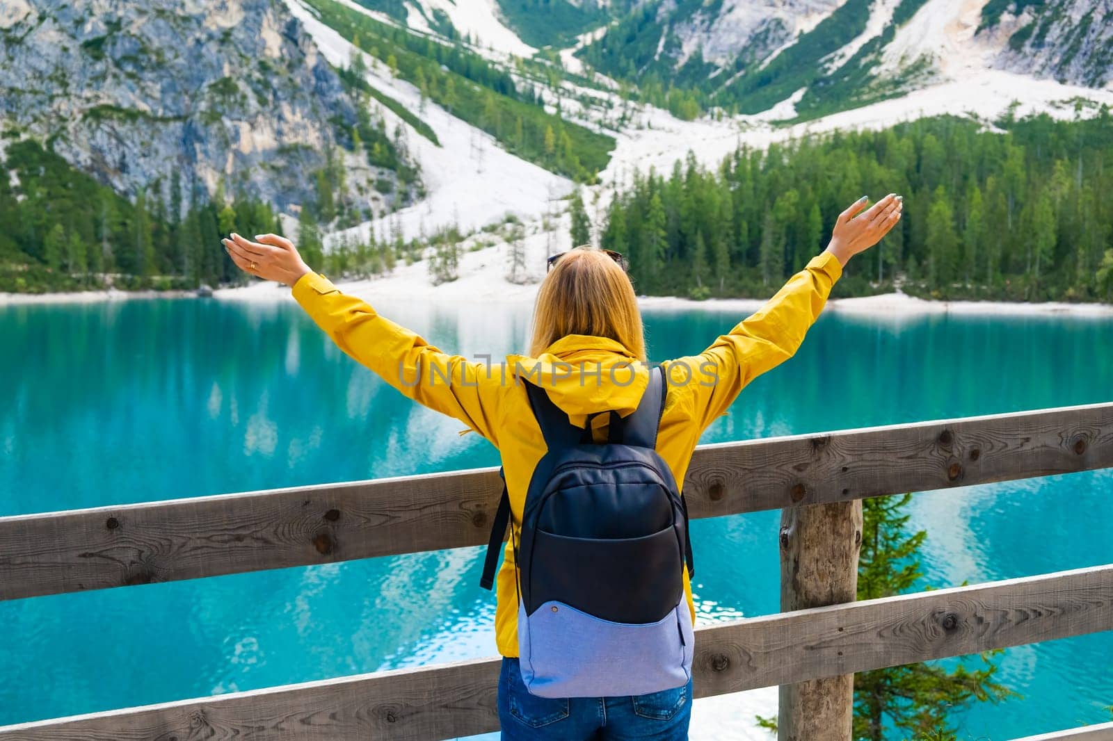 Tourist spends holidays on Lake Braies and enjoys the view of the Dolomites Alps.