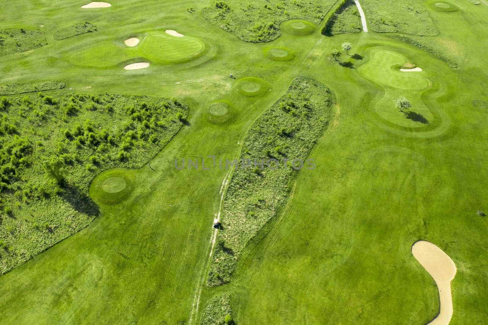 Golf course with sand bunker and green grass, aerial view by vladimka