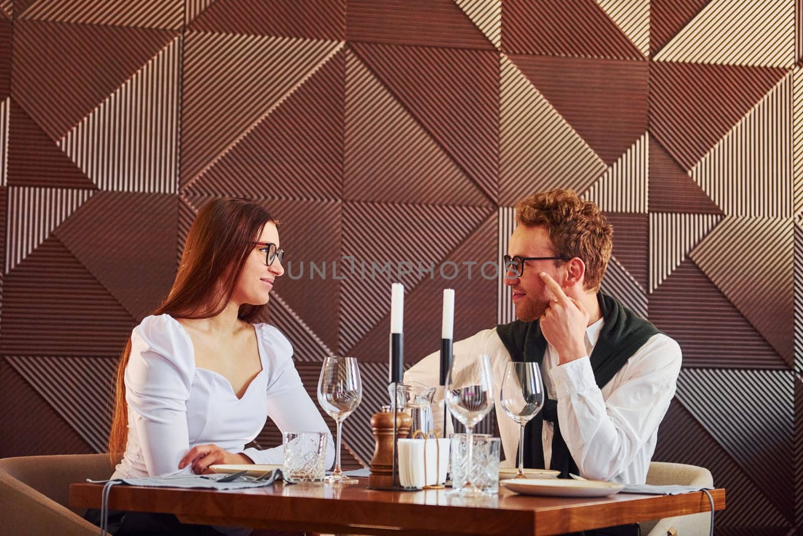 Young boyfriend with adult woman. Indoors of new modern luxury restaurant.