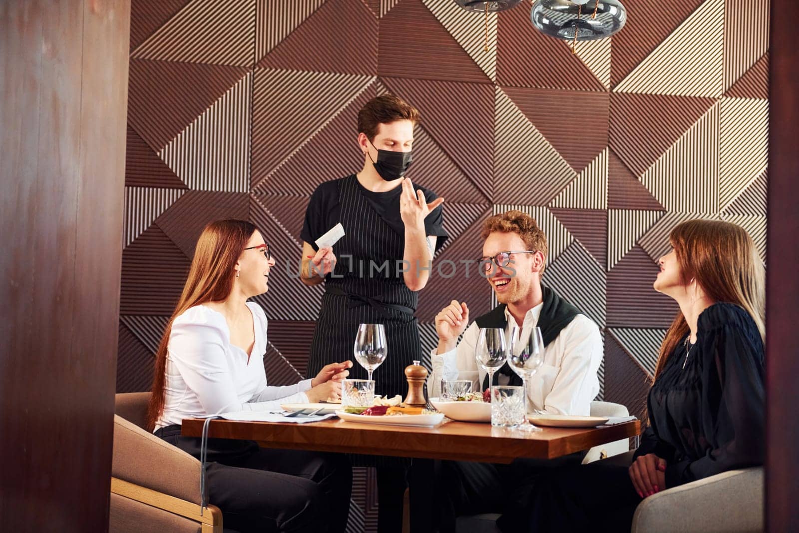 People have a dinner together. Indoors of new modern luxury restaurant.