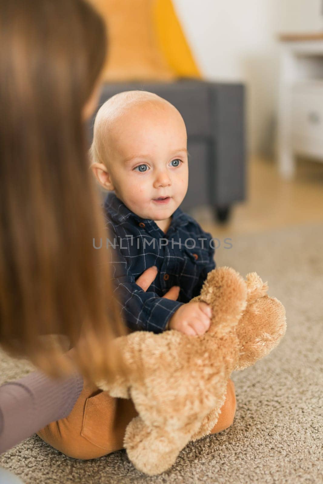Child playing with teddy bear. Little boy hugging his favorite toy