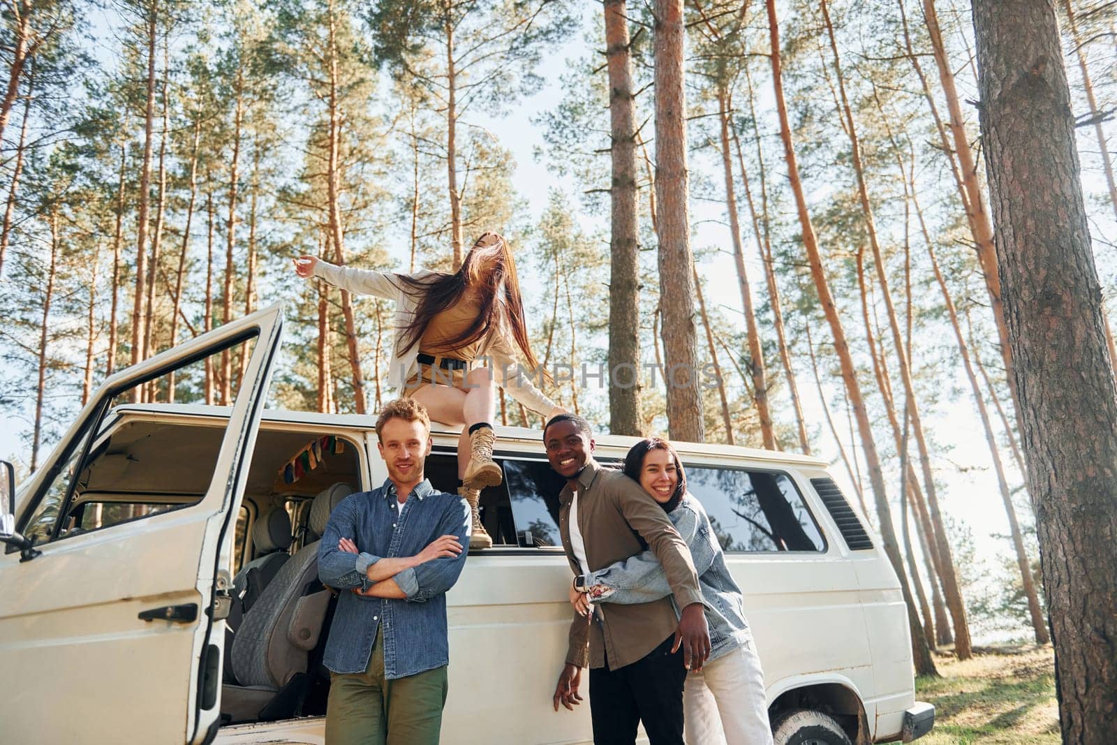 Destination place. Group of young people is traveling together in the forest at daytime.