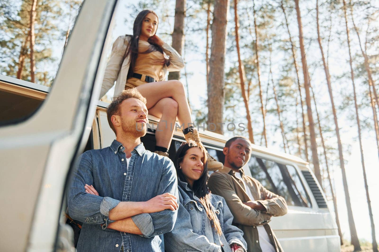 Destination place. Group of young people is traveling together in the forest at daytime.