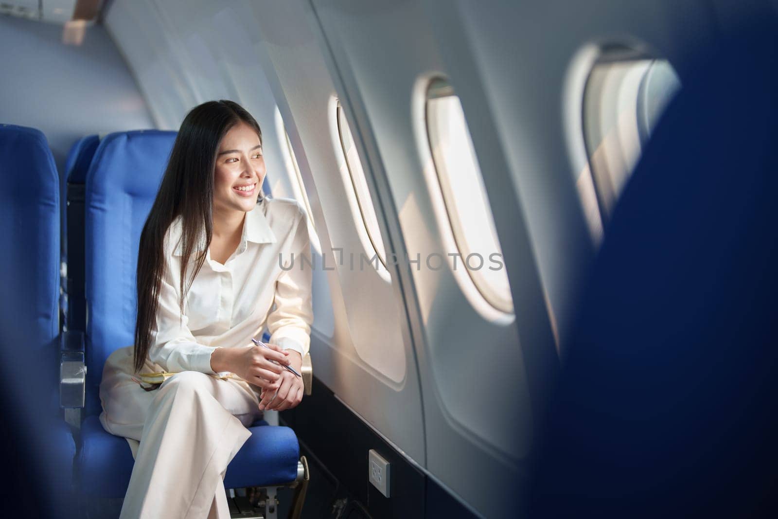 Asian attractive business woman passenger sitting on business class luxury plane while relax while travel concept.