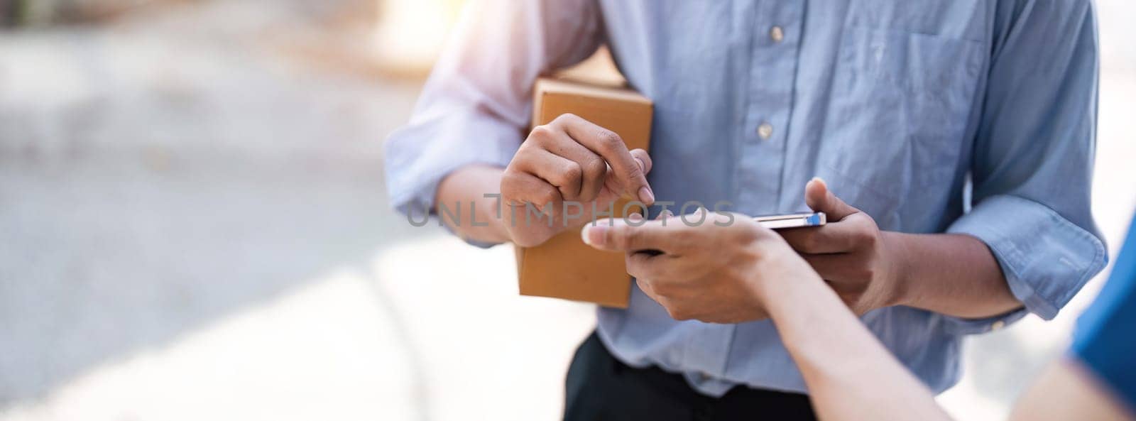 customer signature in mobile phone, man receiving parcel box from courier with delivery service man, express delivery, online shopping concept.