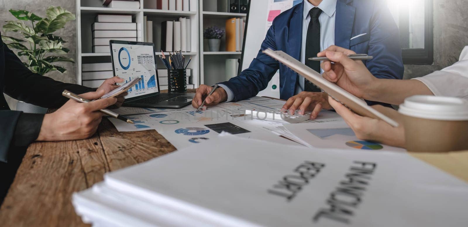 Business People Meeting using laptop computer,calculator,notebook,stock market chart paper for analysis Plans to improve quality next month. Conference Discussion Corporate Concept....