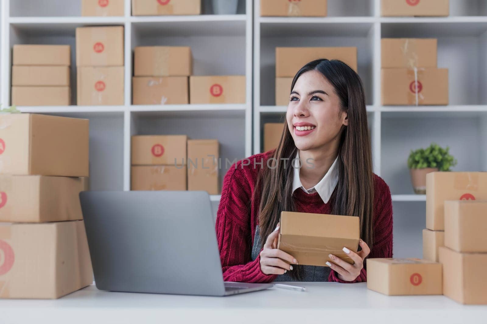 Startup small business entrepreneur SME, asian woman packing cloth in box. Portrait young Asian small business owner home office, online sell marketing delivery, SME e-commerce telemarketing concept. by wichayada