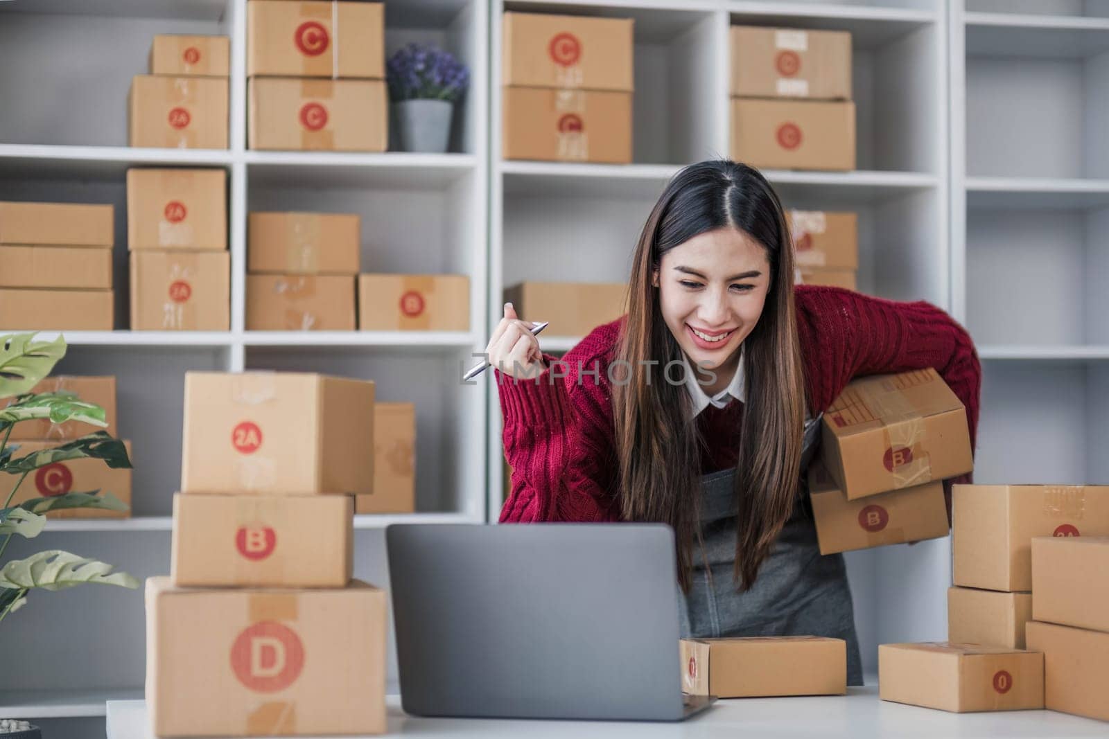 Startup small business entrepreneur SME, asian woman packing cloth in box. Portrait young Asian small business owner home office, online sell marketing delivery, SME e-commerce telemarketing concept. by wichayada