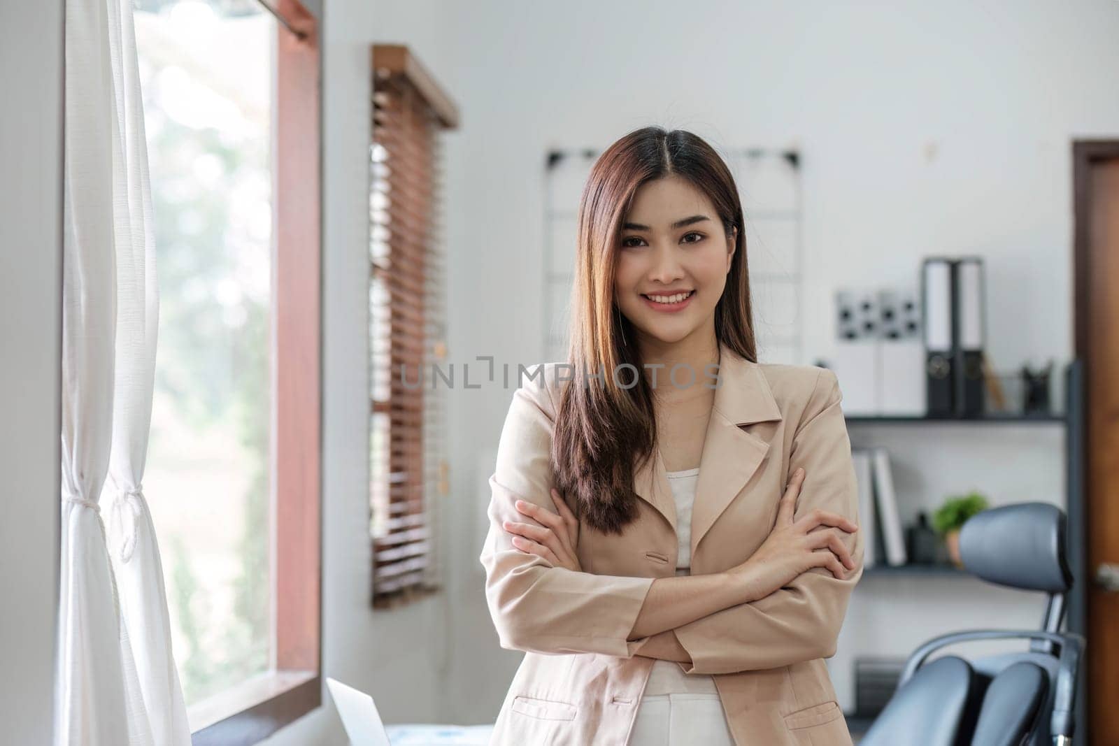 Confident Asian businesswoman standing with her arms crossed. smiling and looking at the camera...
