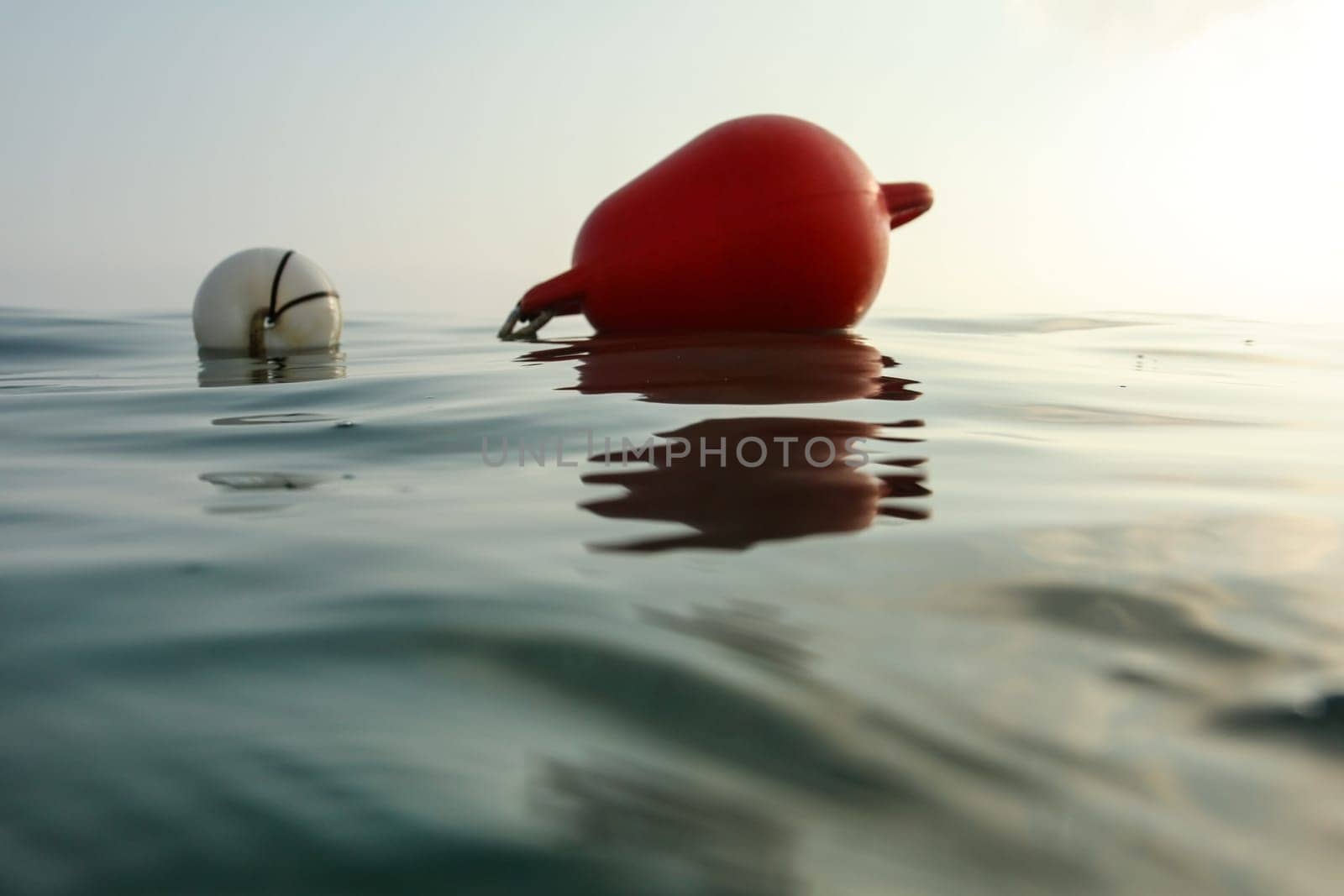 Sea surface photographed from water level, sea buoy in back. Abstract marine background.