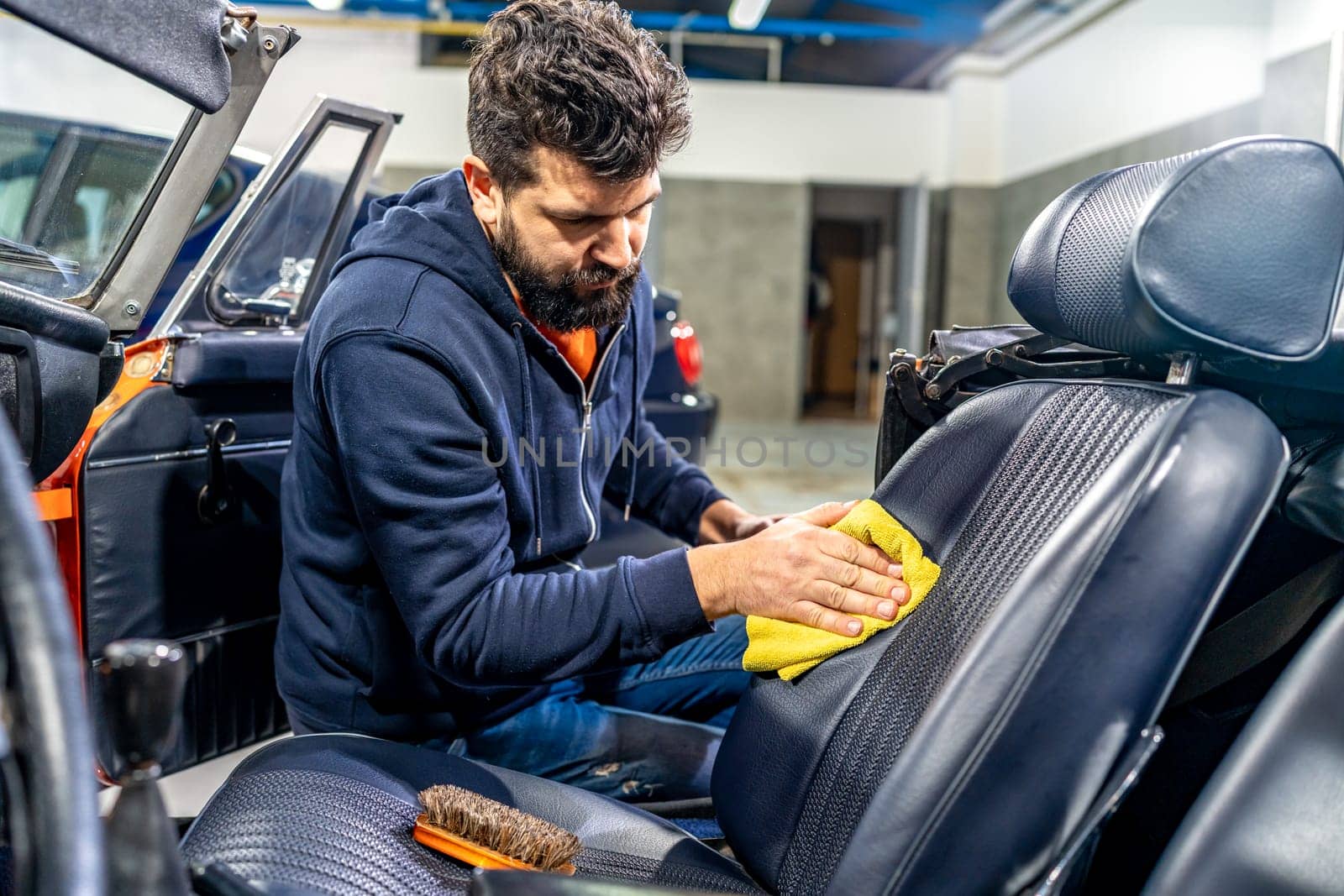 manual cleaning of the leather in the interior of the car with a micro towel by Edophoto