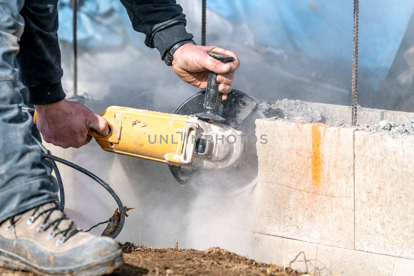 cutting concrete bricks with an electric grinder.