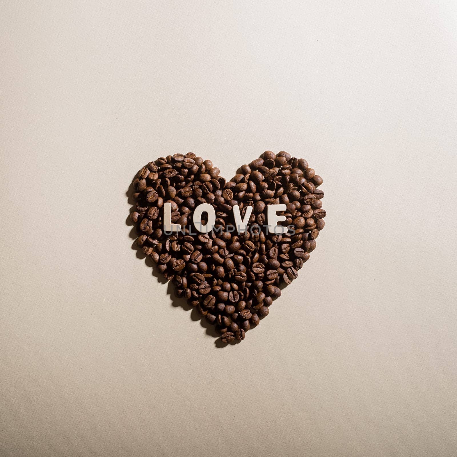 Close-up of coffee beans in the shape of a heart and the inscription love by mrwed54