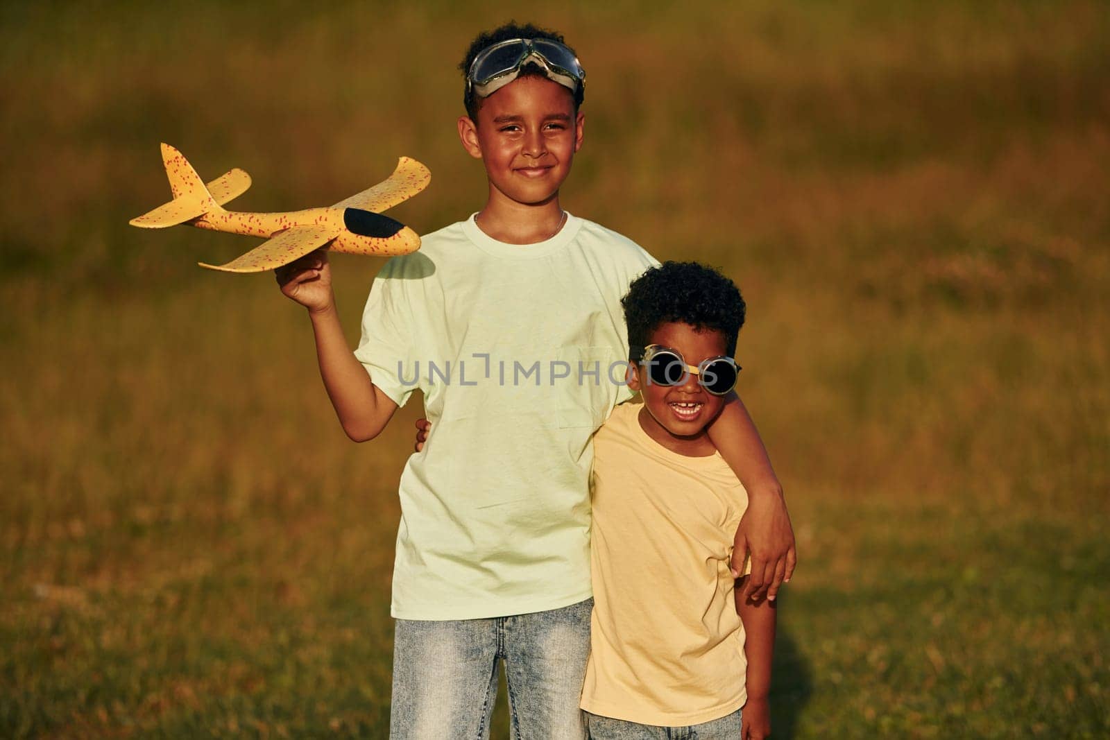 At summer daytime together. Two african american kids have fun in the field.