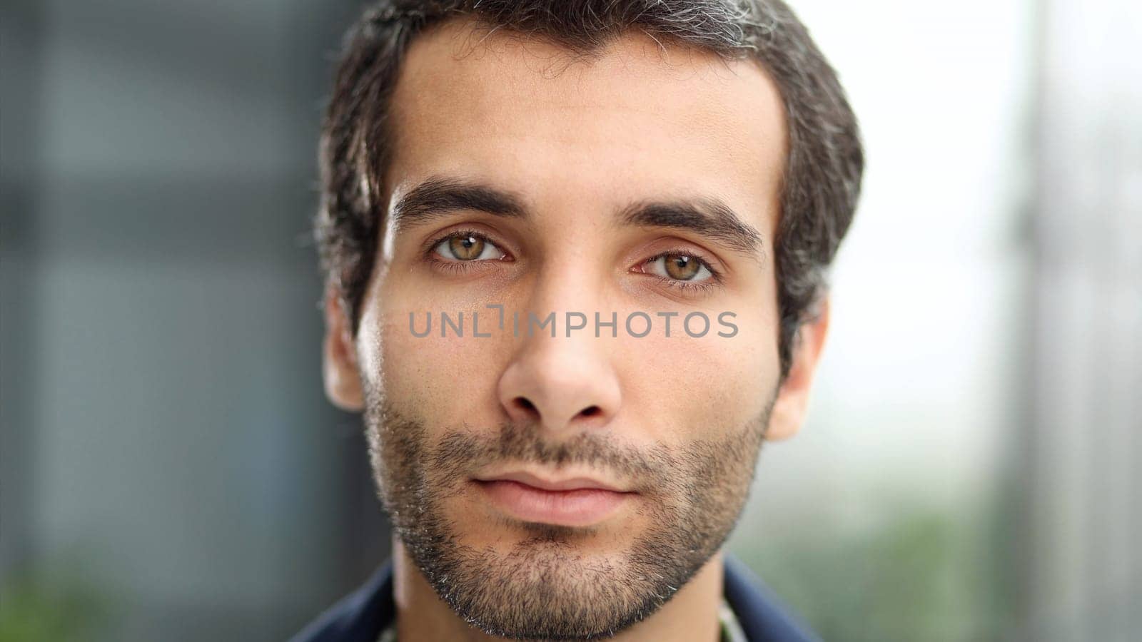 Close-up portrait of a confident businessman, against the backdrop of a modern office
