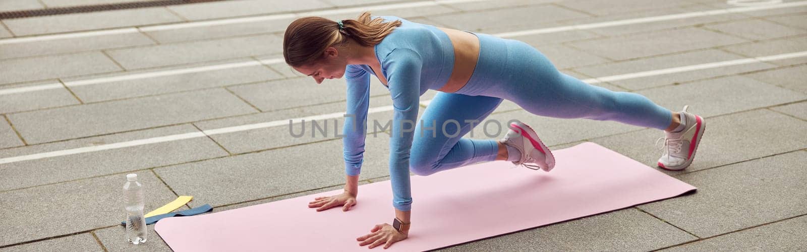 Beautiful fit caucasian woman is doing exercises outdoors at the city by Yaroslav_astakhov