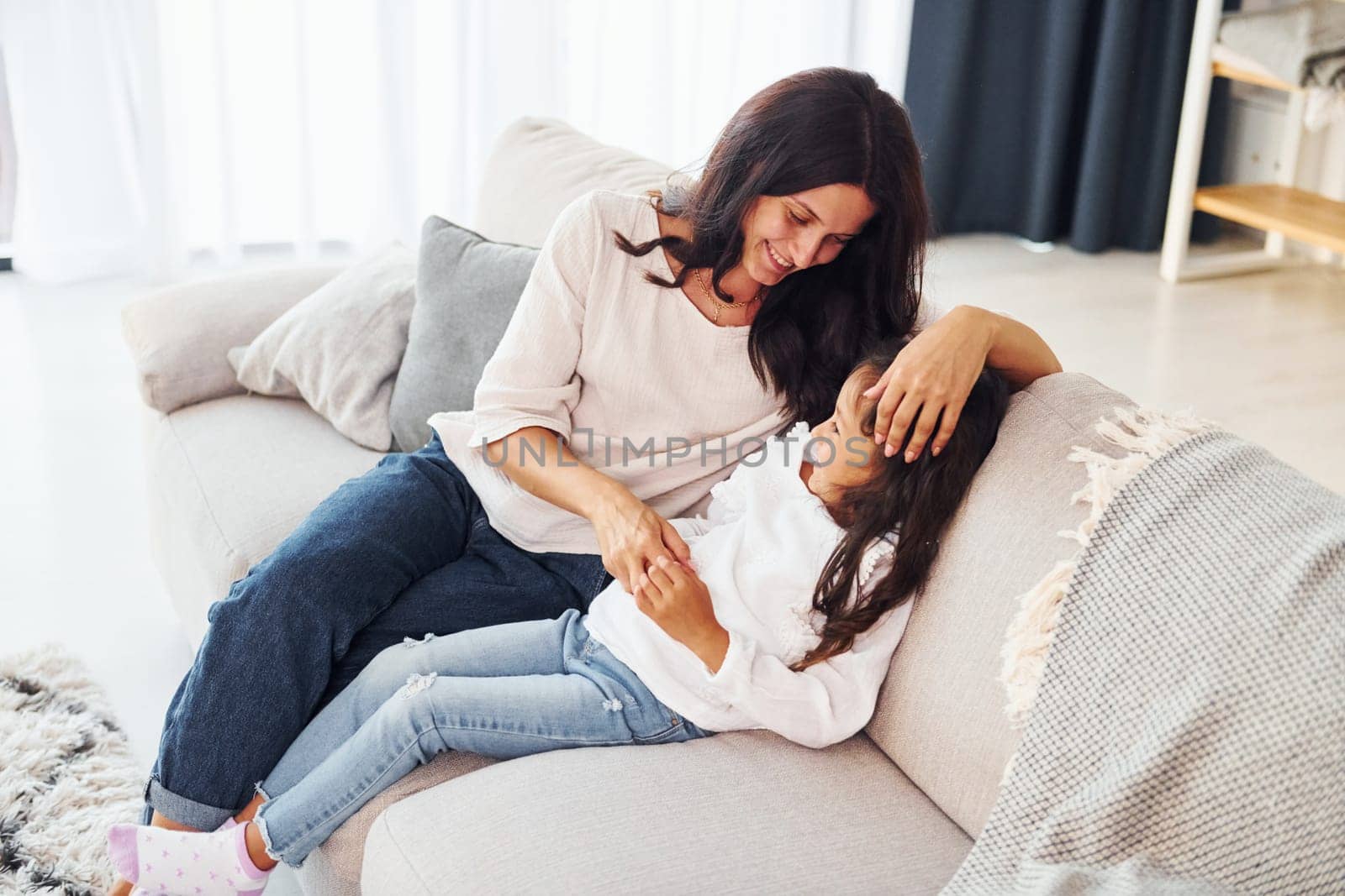 Modern interior. Mother and her daughter spending time together at home.