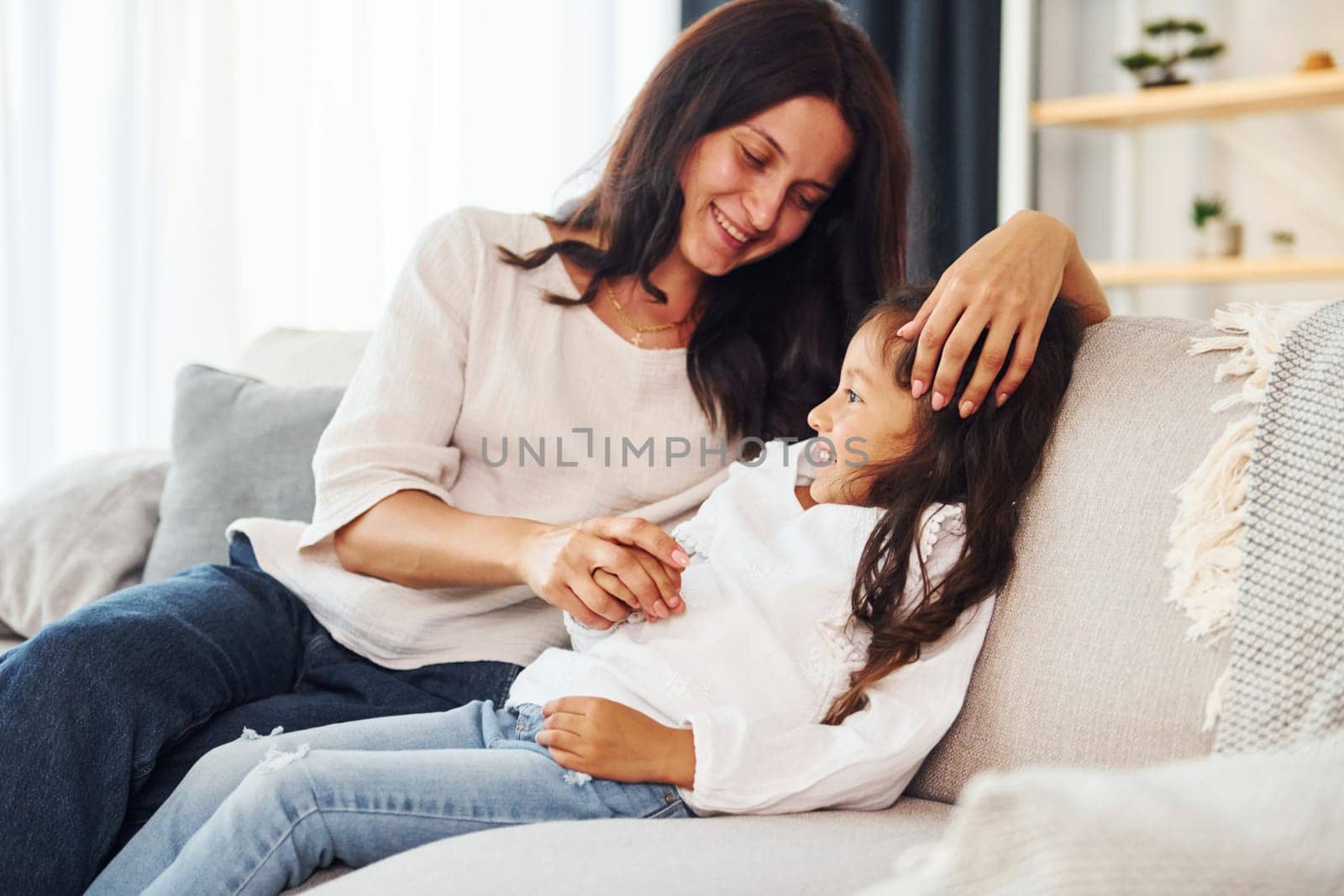 Modern interior. Mother and her daughter spending time together at home.