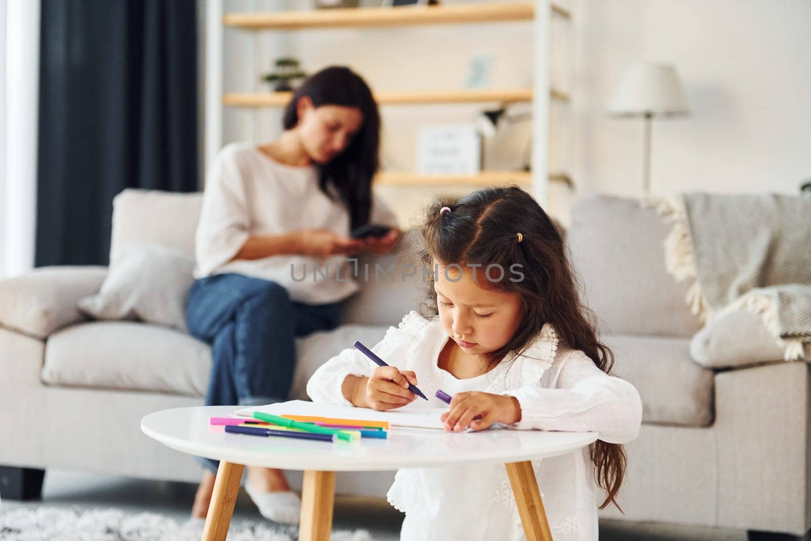 Modern design. Mother and her daughter spending time together at home.