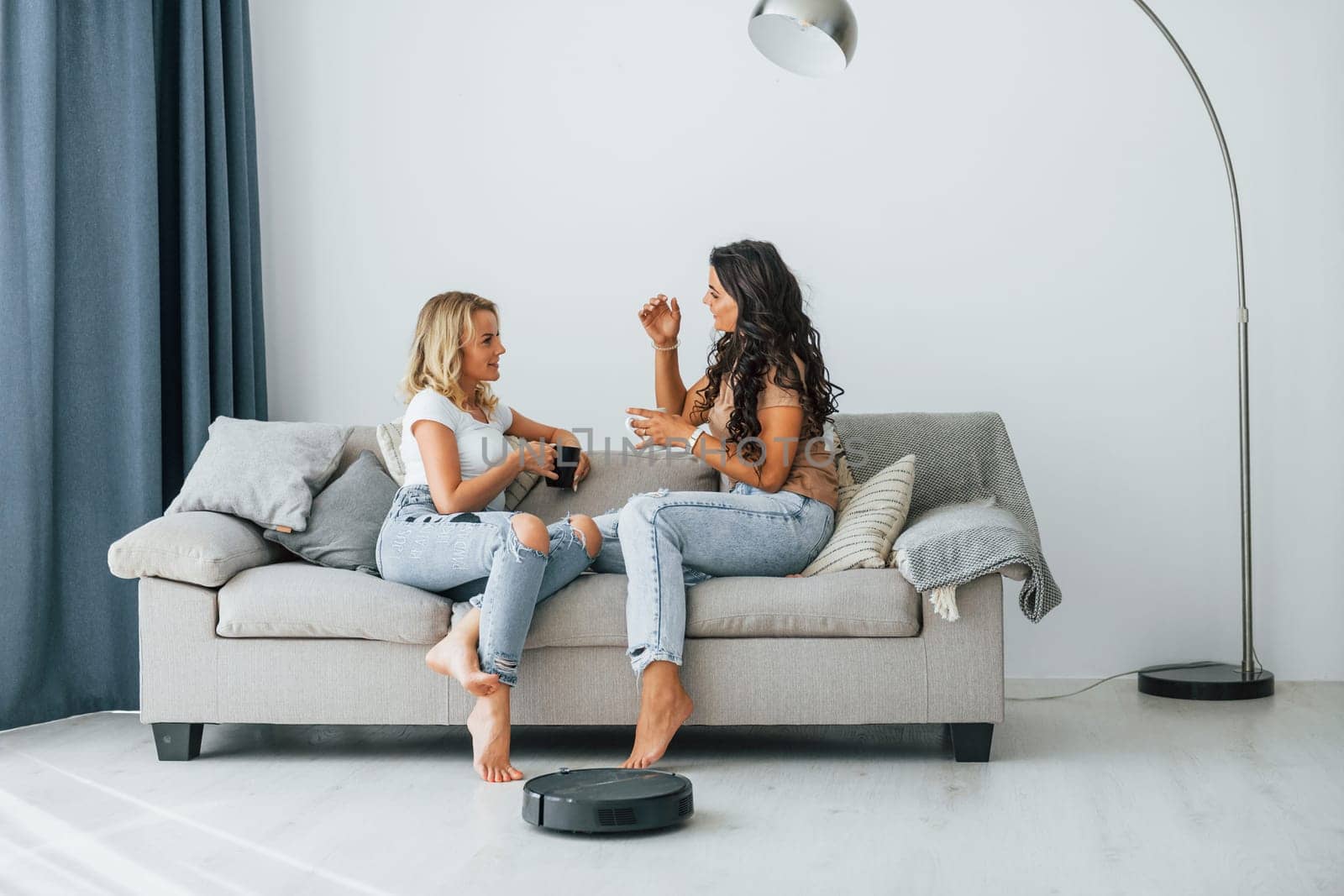 Sitting on bed. Two women is together at home.