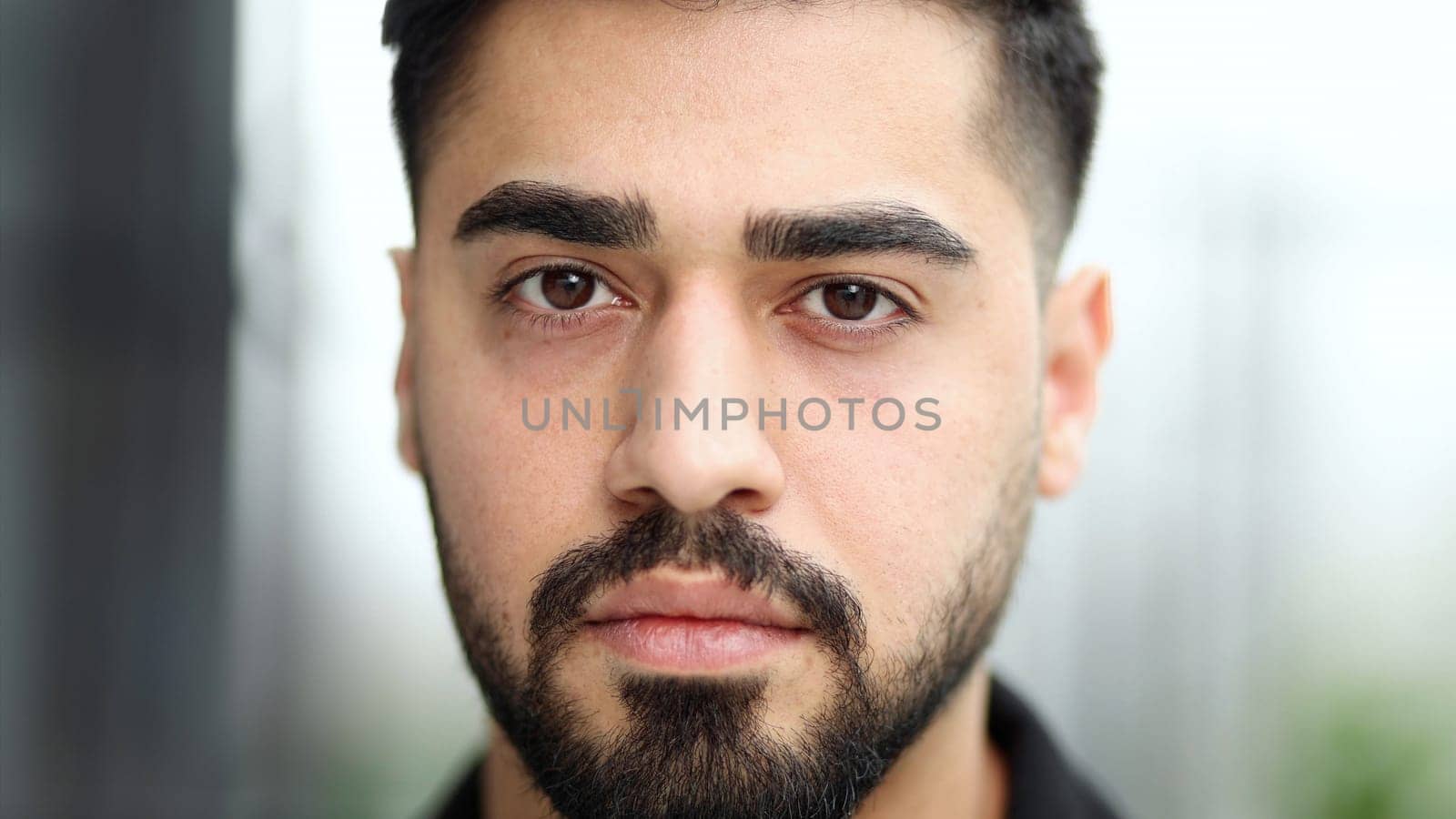 Close-up of a man's face. Man confidently looking at the camera
