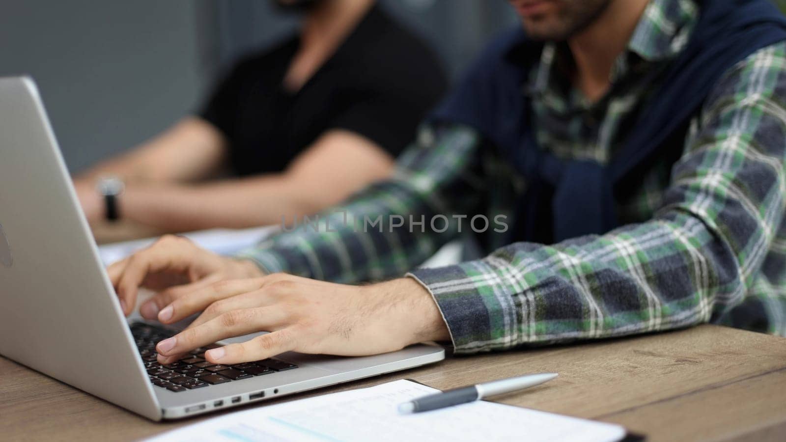 hands of a man on a laptop sitting at a table in the office
