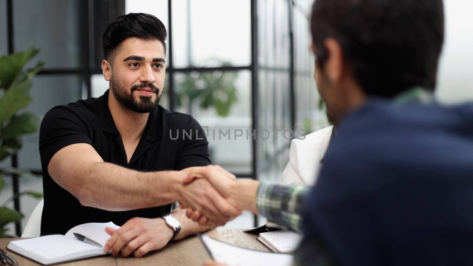 Group of business people sitting two men handshaking