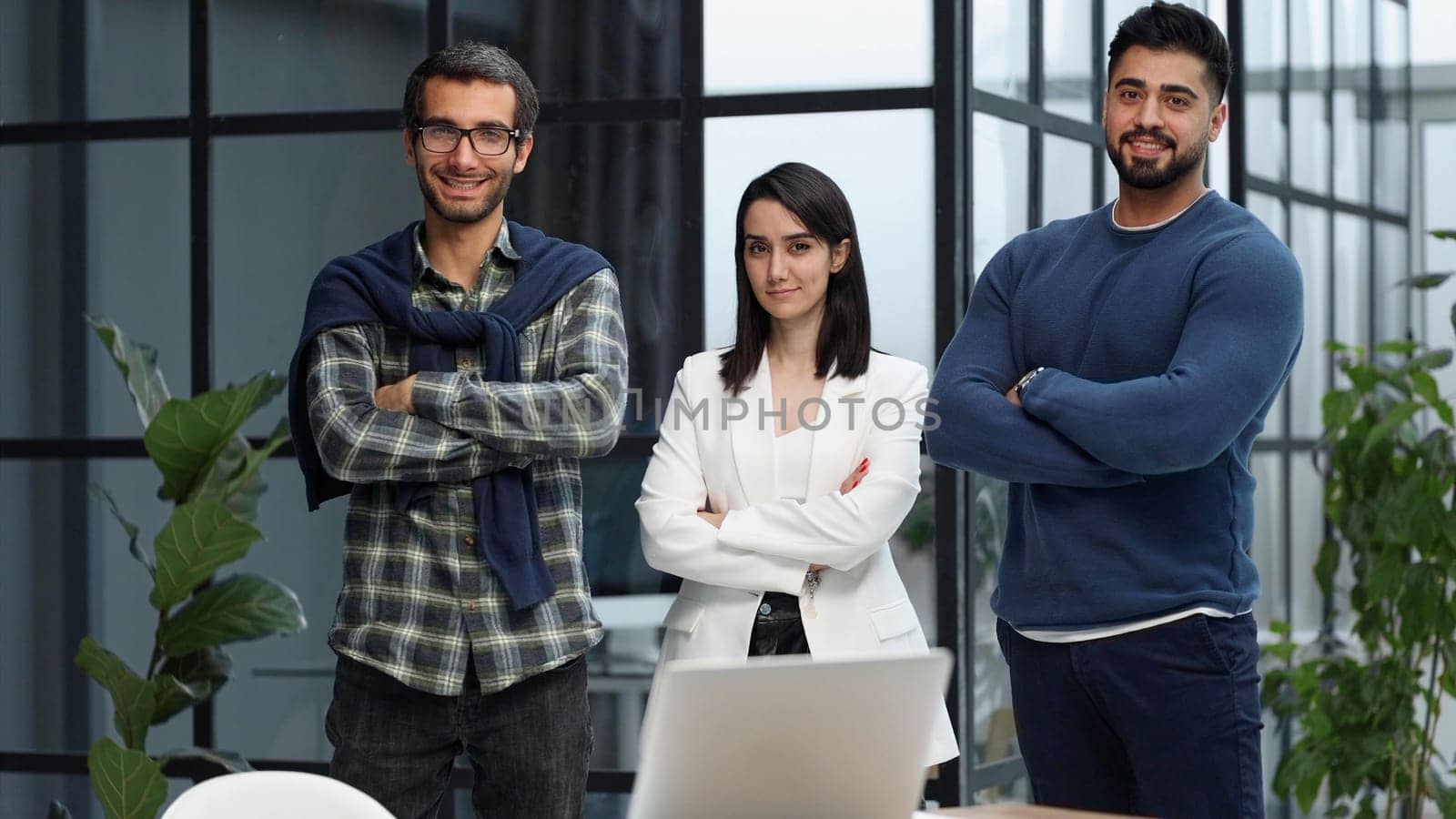 three colleagues stand in the lobby of a modern office