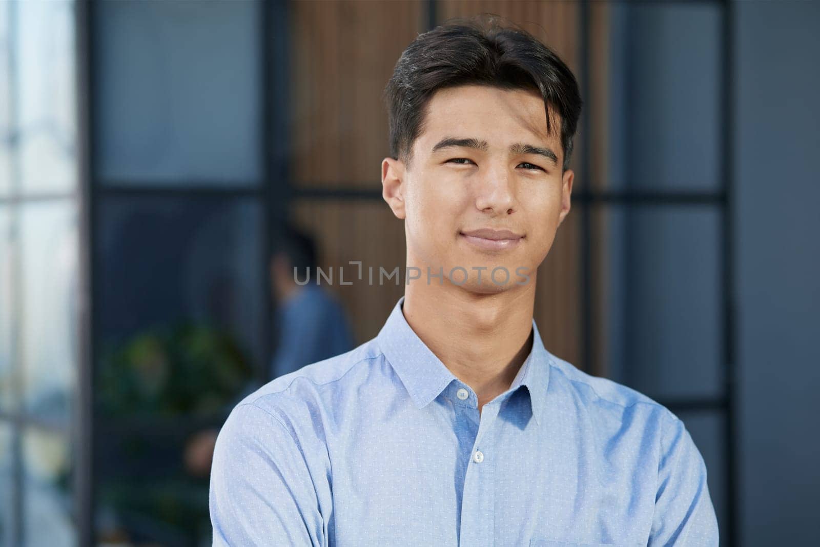 Close-up of smiling asian businessman standing in modern office