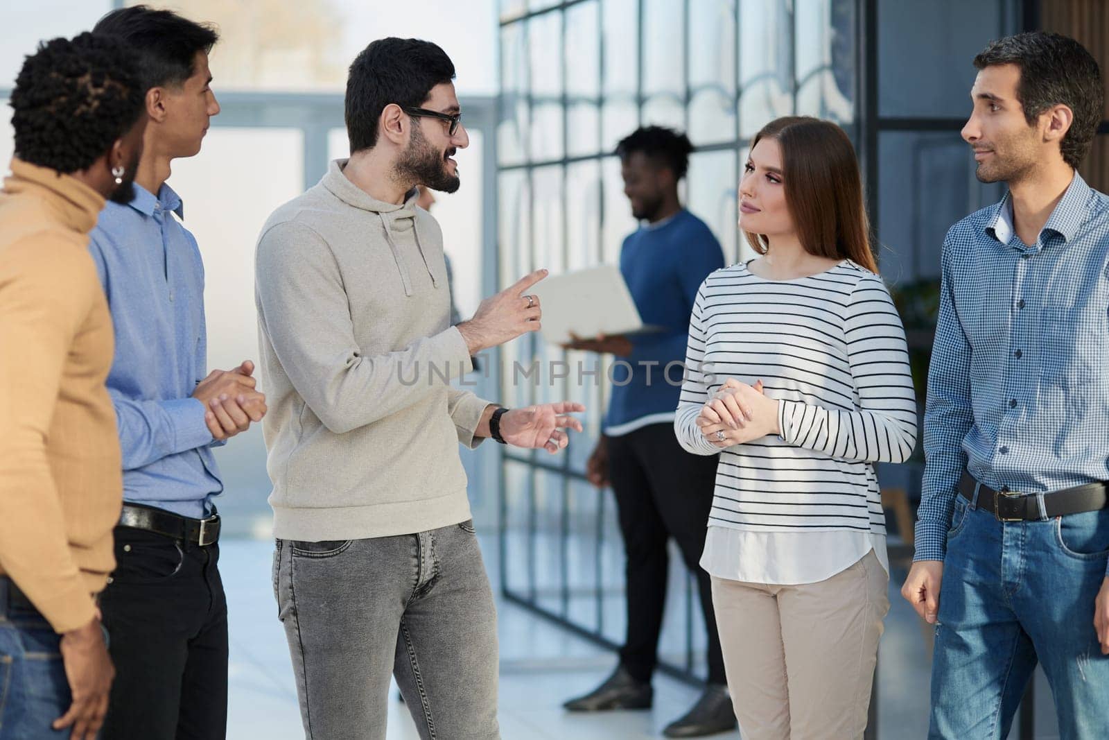 Laughing multiethnic business people talking in the office.