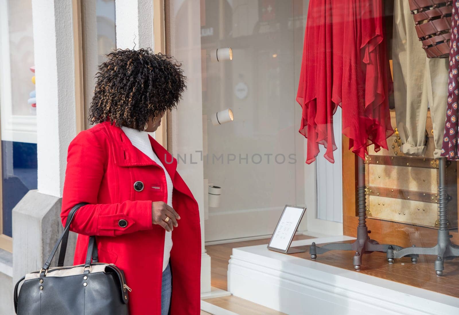 curvy african american woman with shopping bags standing on the street by KaterinaDalemans