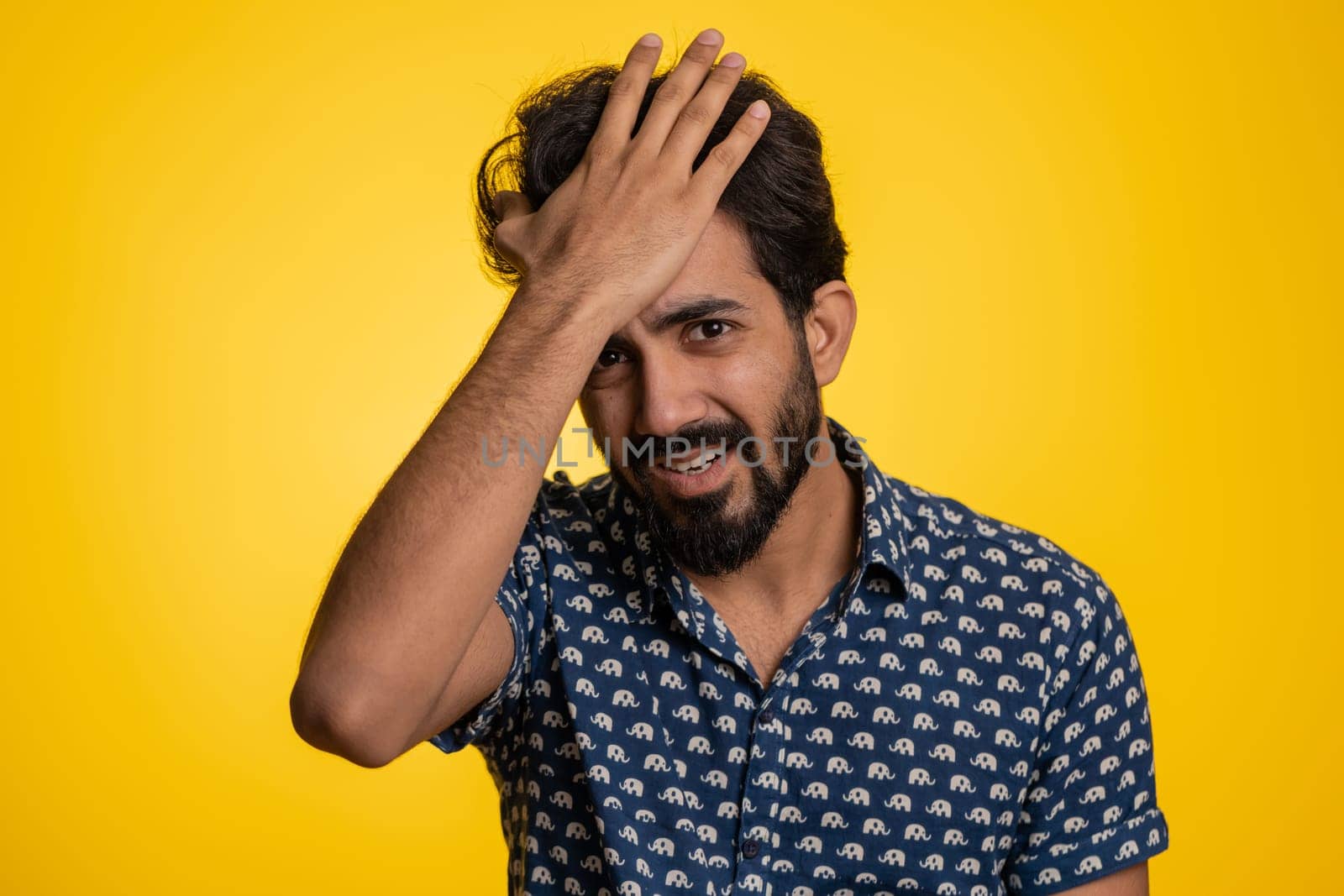 Bearded indian man feeling hopelessness loneliness, nervous breakdown, loses becoming surprised by lottery results, bad fortune loss, unlucky news. Hindu young guy isolated on studio yellow background