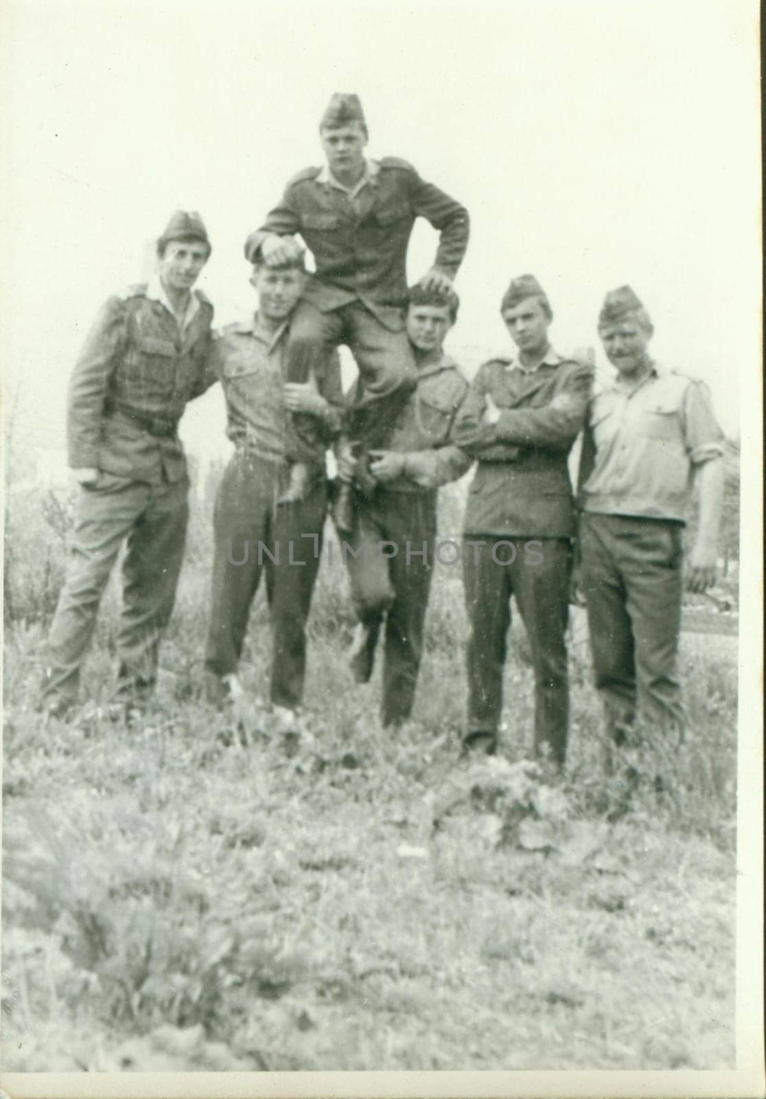 Retro photo shows young men - soldiers pose outdoors. Vintage photography. Circa 1970. by roman_nerud