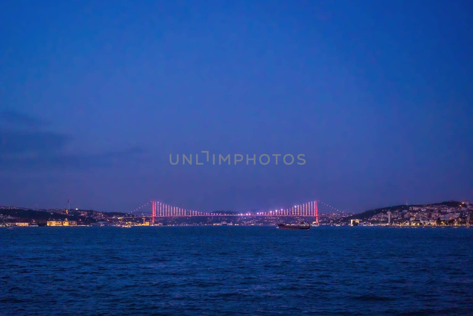 Istanbul at sunset, Turkey. Tourist boat sails on Golden Horn in summer. Beautiful sunny view of Istanbul waterfront with old mosque. Concept of travel, tourism and vacation in Istanbul and Turkey. Turkiye.